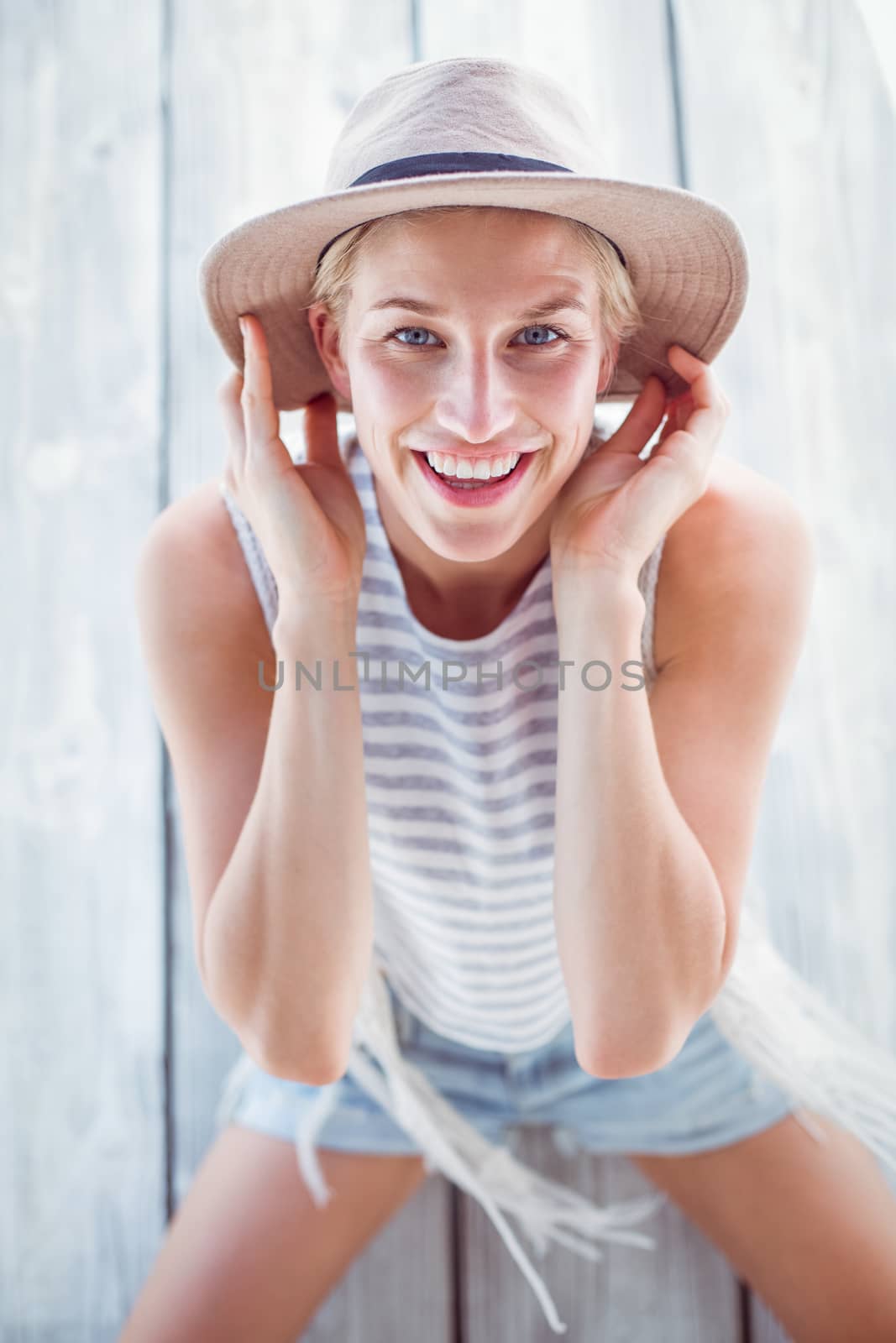 Pretty blonde woman wearing hat and smiling at camera by Wavebreakmedia