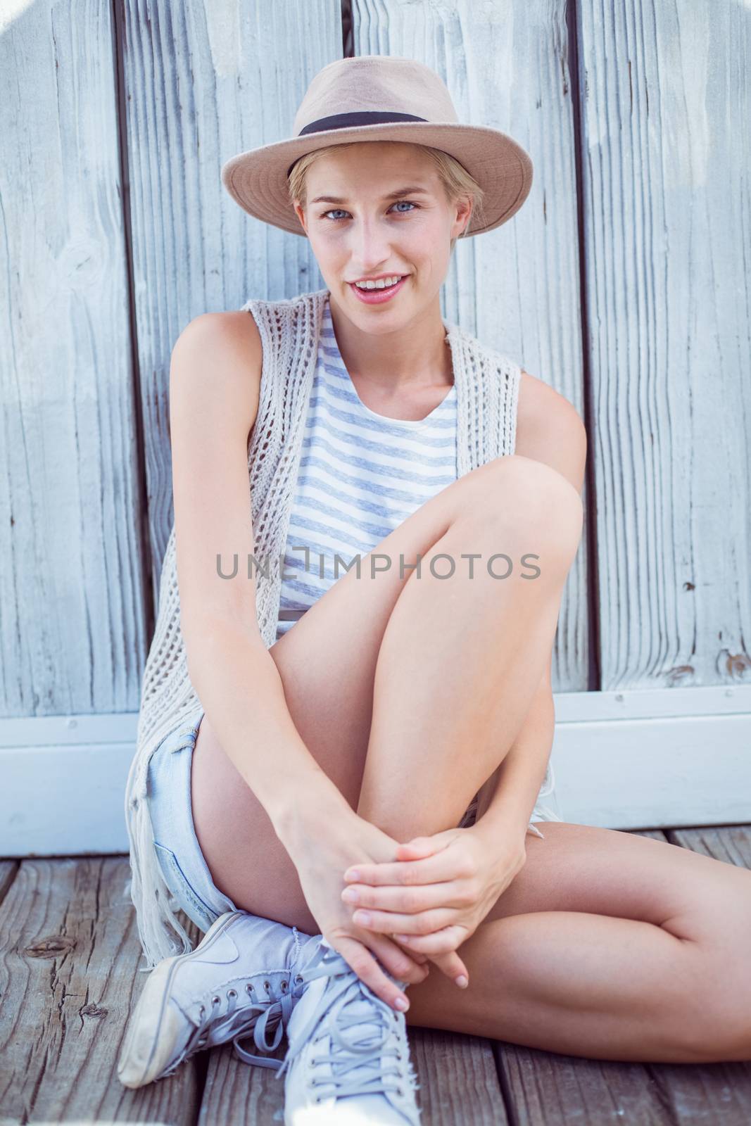 Pretty blonde woman wearing hat and smiling at camera by Wavebreakmedia