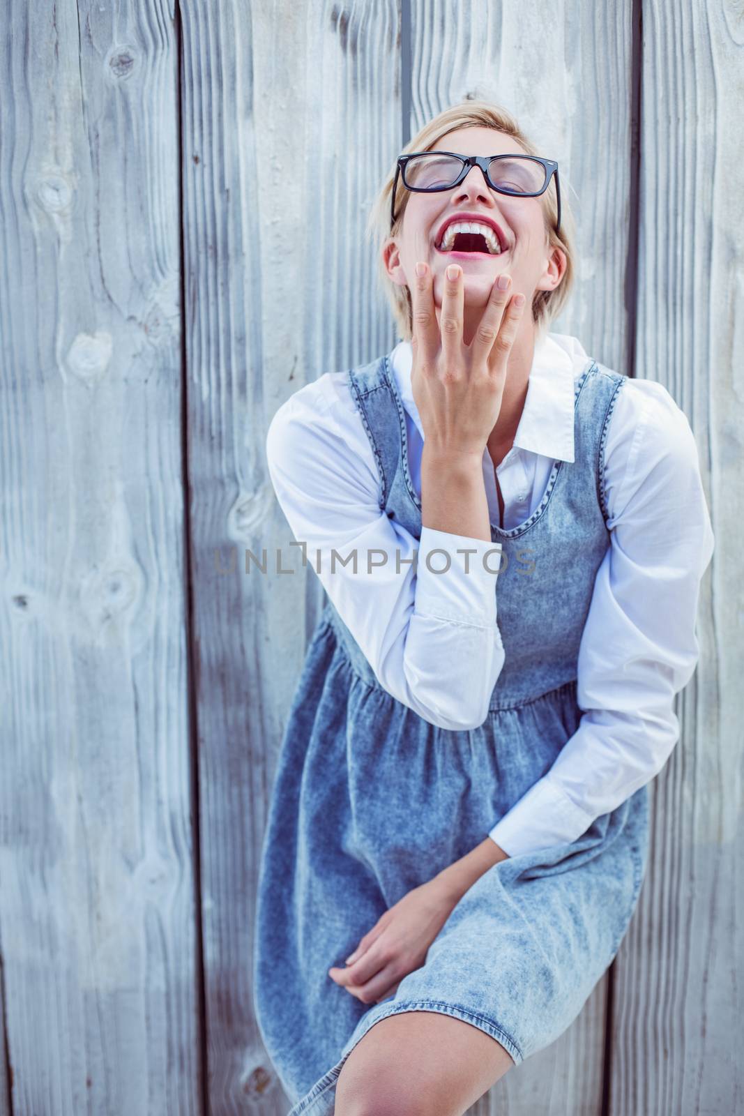 Pretty blonde woman having fun on wooden background