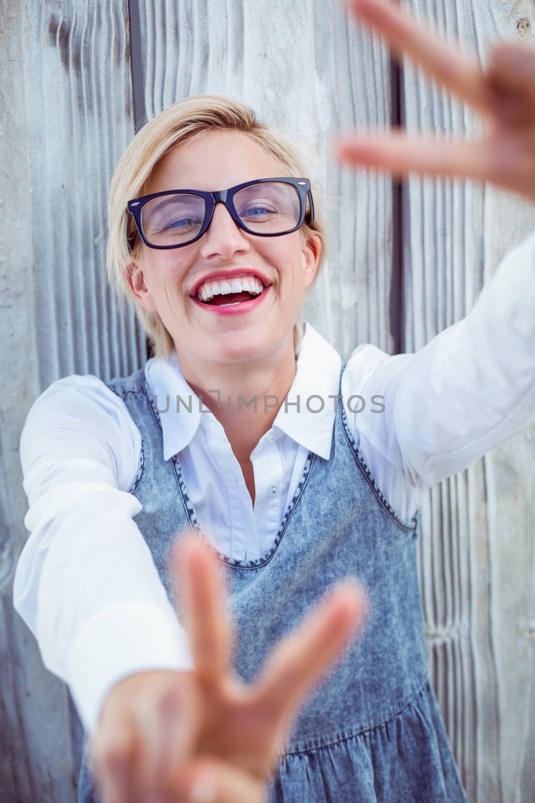 Pretty blonde woman wearing hipster glasses on wooden background