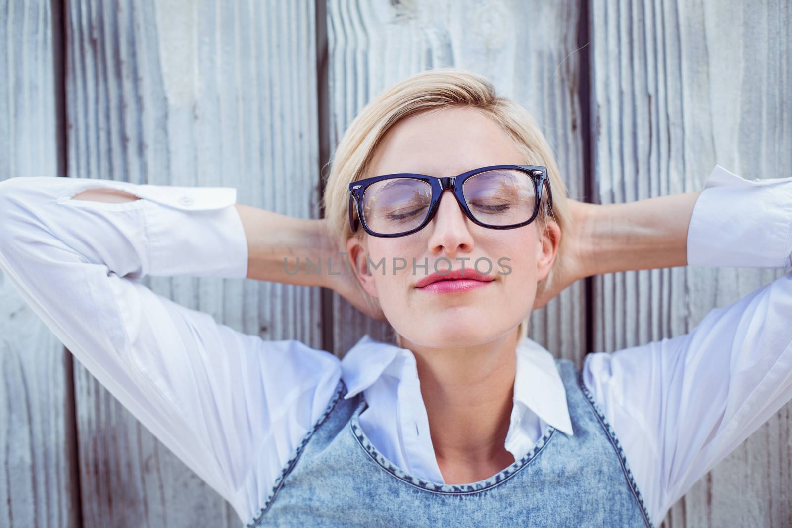 Pretty blonde woman relaxing on wooden background