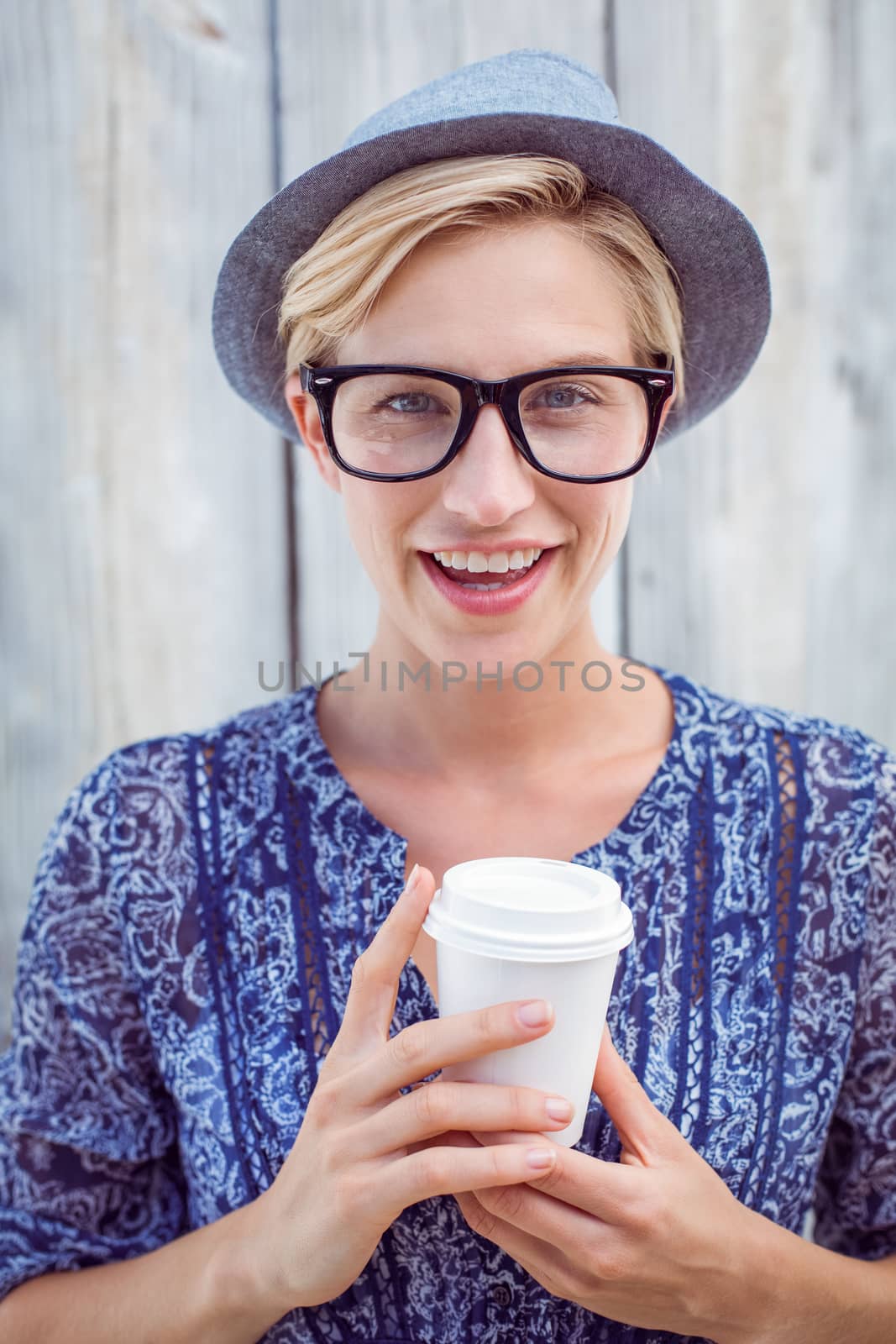 Pretty blonde woman holding goblet on wooden background