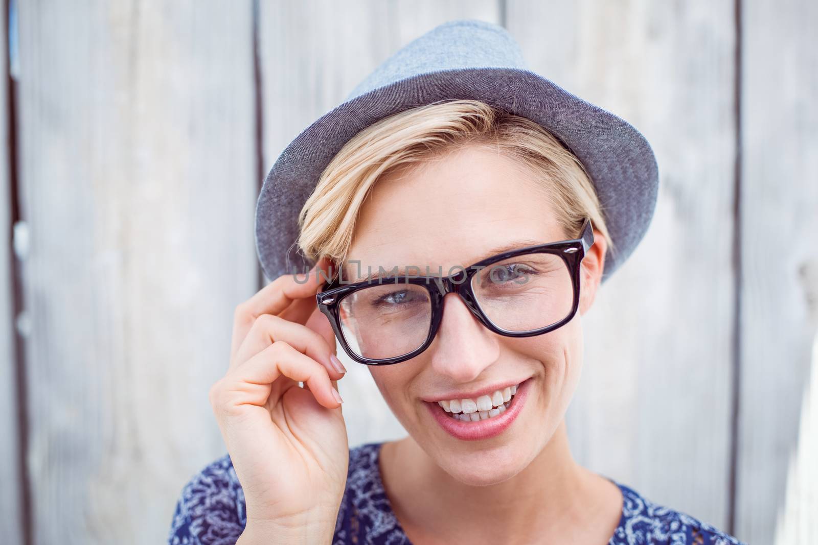 Pretty blonde woman wearing hipster glasses on wooden background