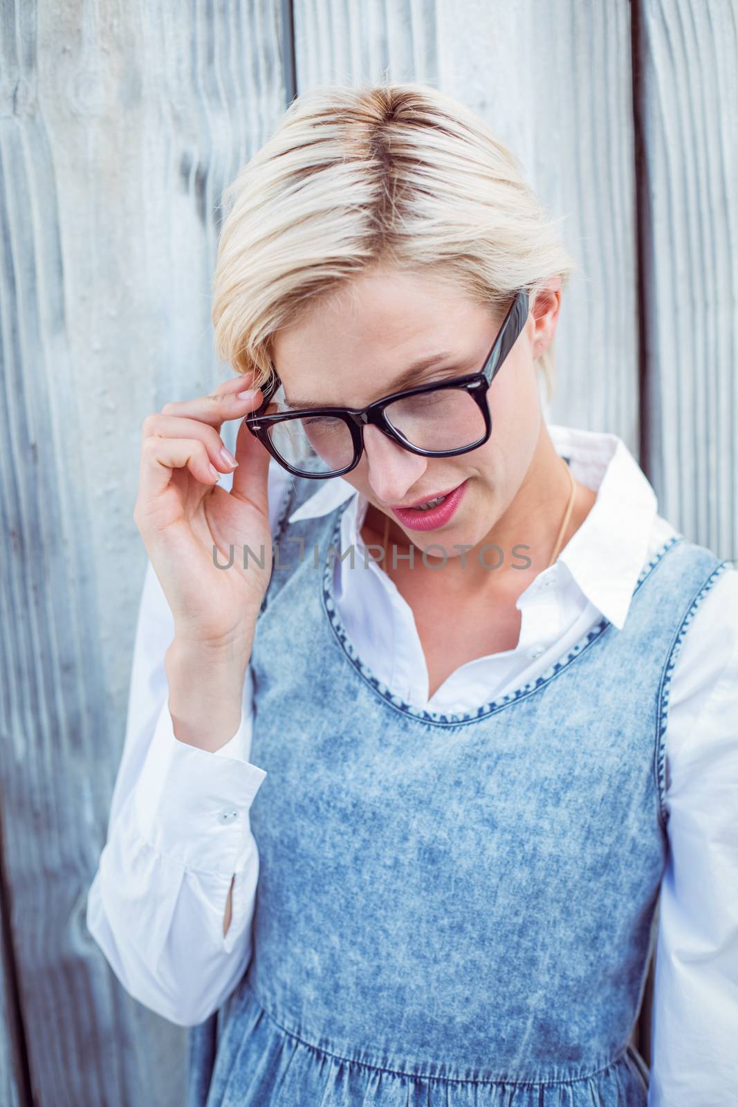 Pretty blonde woman wearing hipster glasses on wooden background