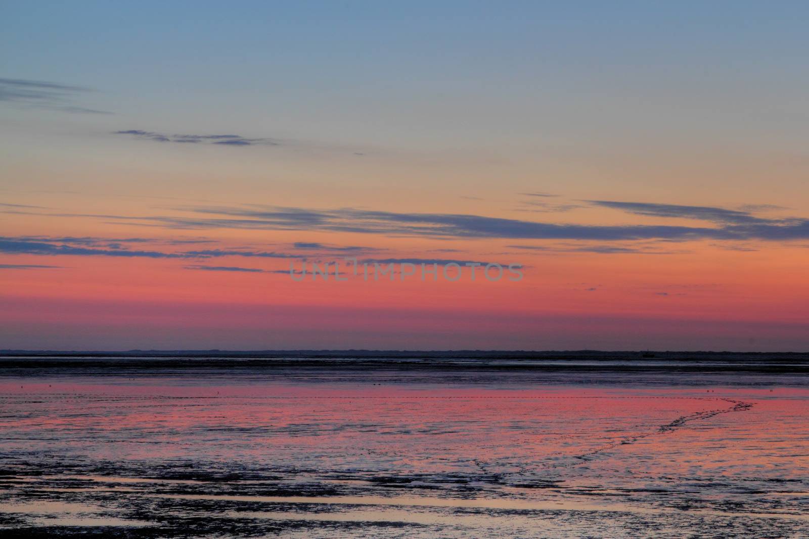 sun going down over mudflat at the german north sea coast