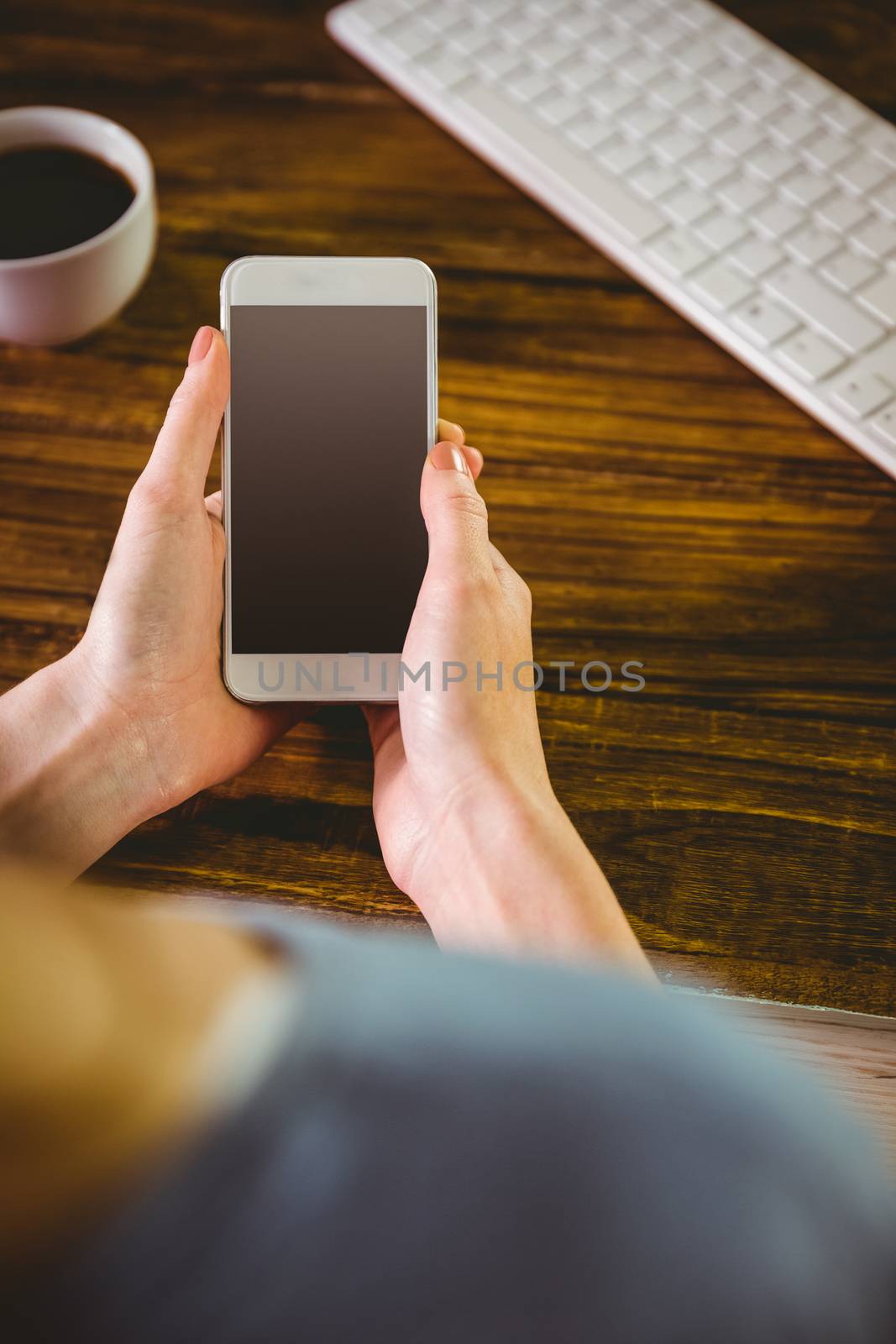 Woman using her smartphone on wooden table