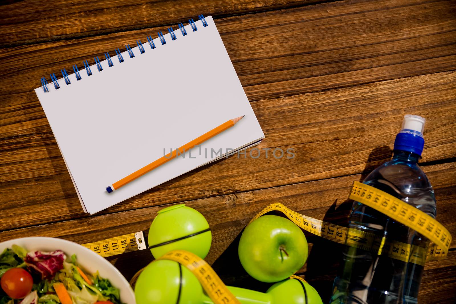 Notepad with indicators of healthy lifestyle on wooden table