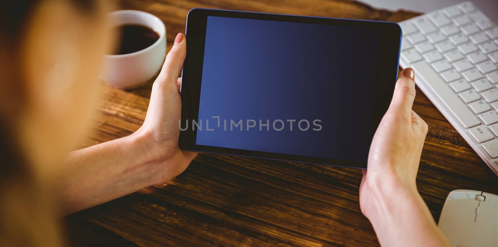 Woman using her tablet pc on wooden table