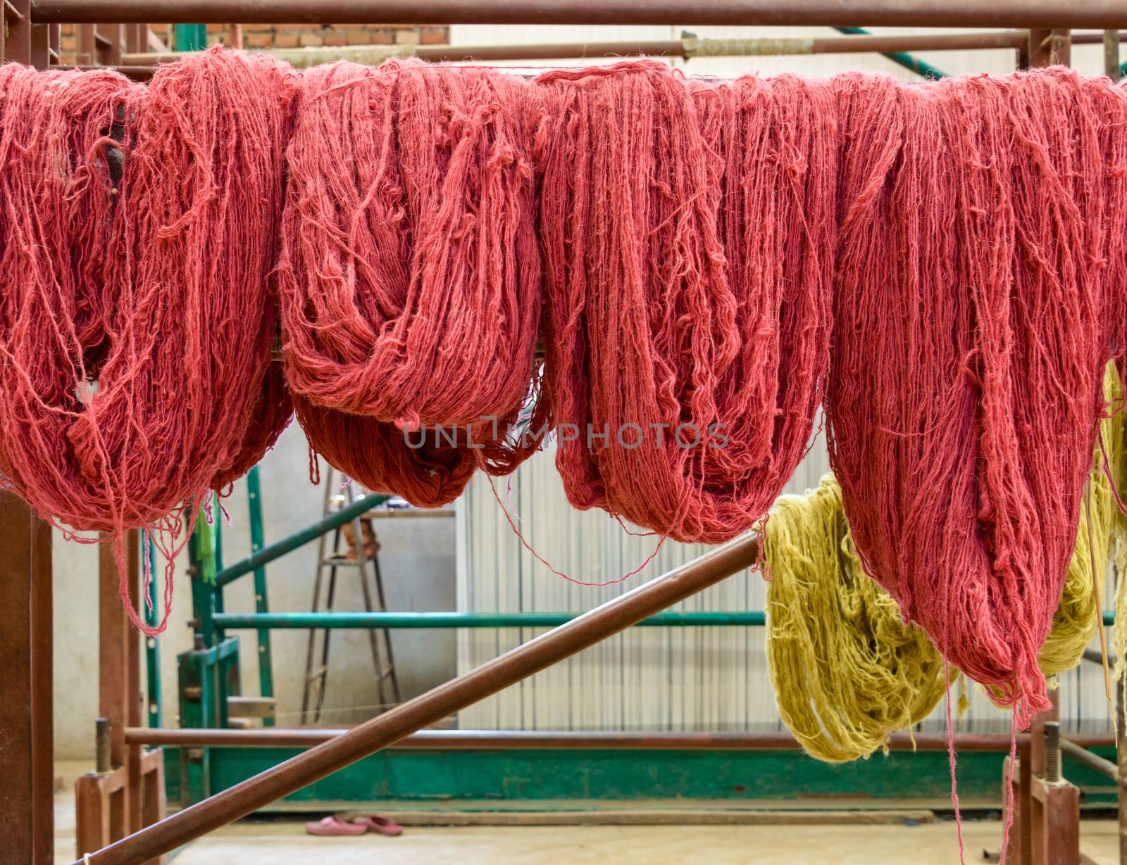 Red wool hanging in a carpet factory