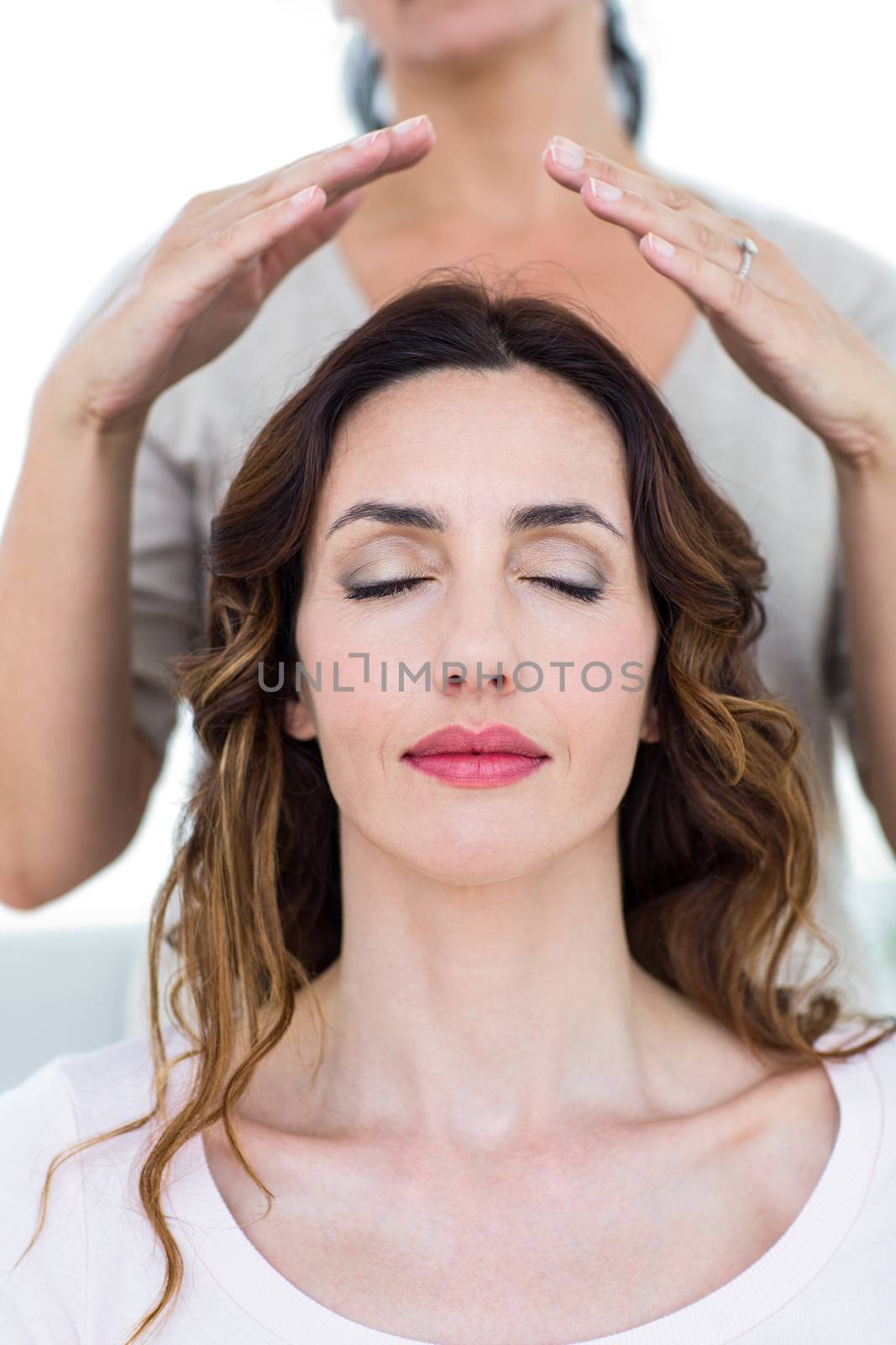 Woman getting reiki therapy on white background