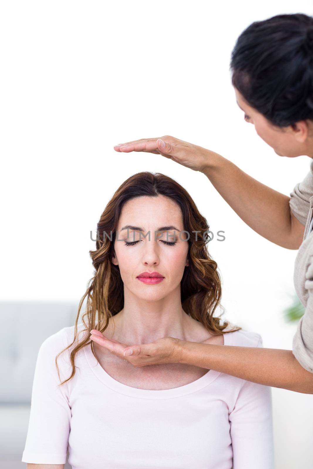 Calm woman receiving reiki treatment on white background