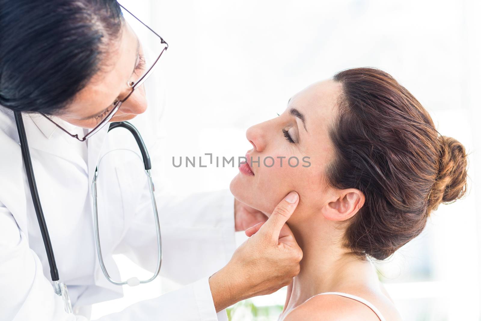 Doctor examining her patients jaw by Wavebreakmedia