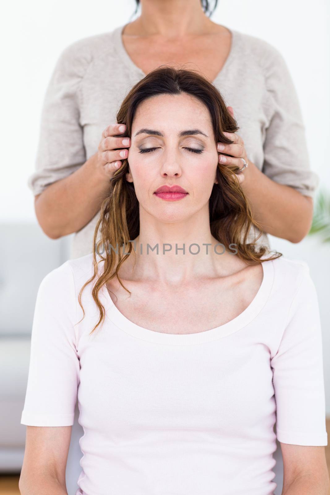 Calm woman receiving reiki treatment on white background
