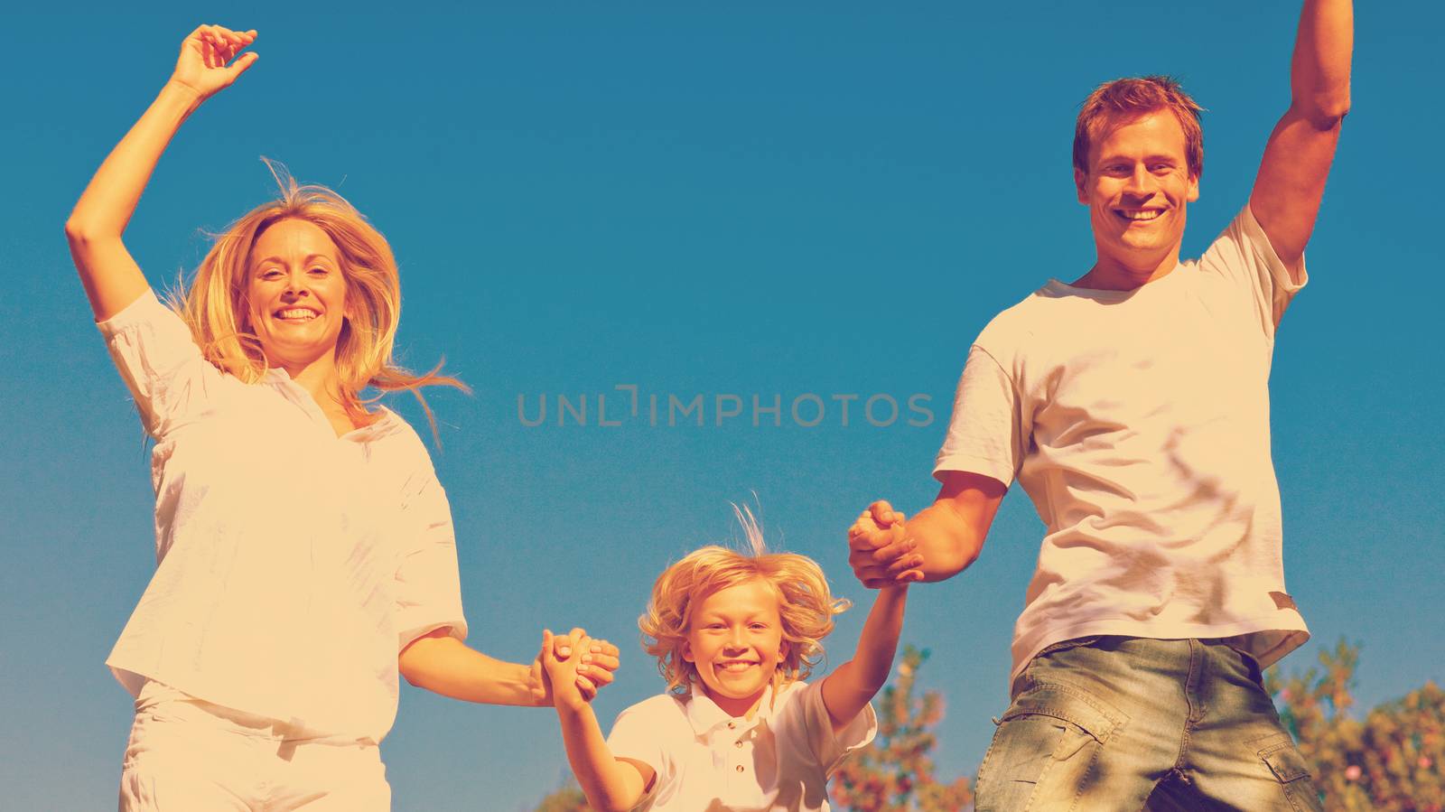 Beautiful family playing in the garden against a blue sky background
