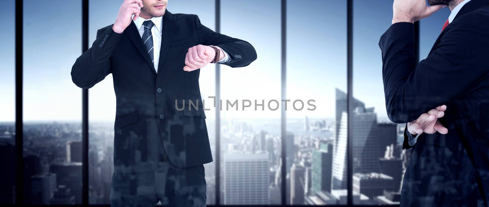 Serious businessman phoning while checking time against room with large window looking on city
