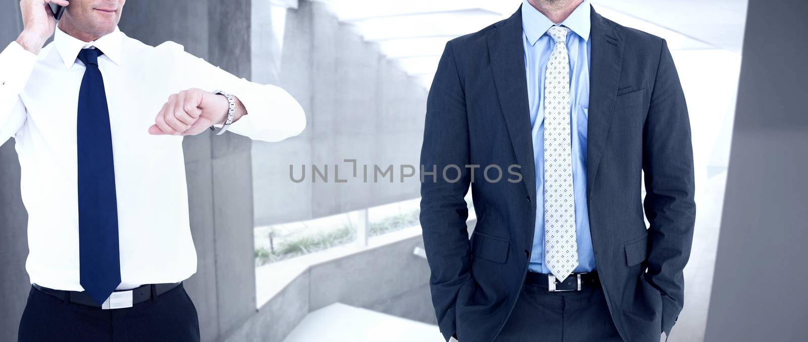 Businessman on the phone looking at his wrist watch against stylish modern home interior with staircase