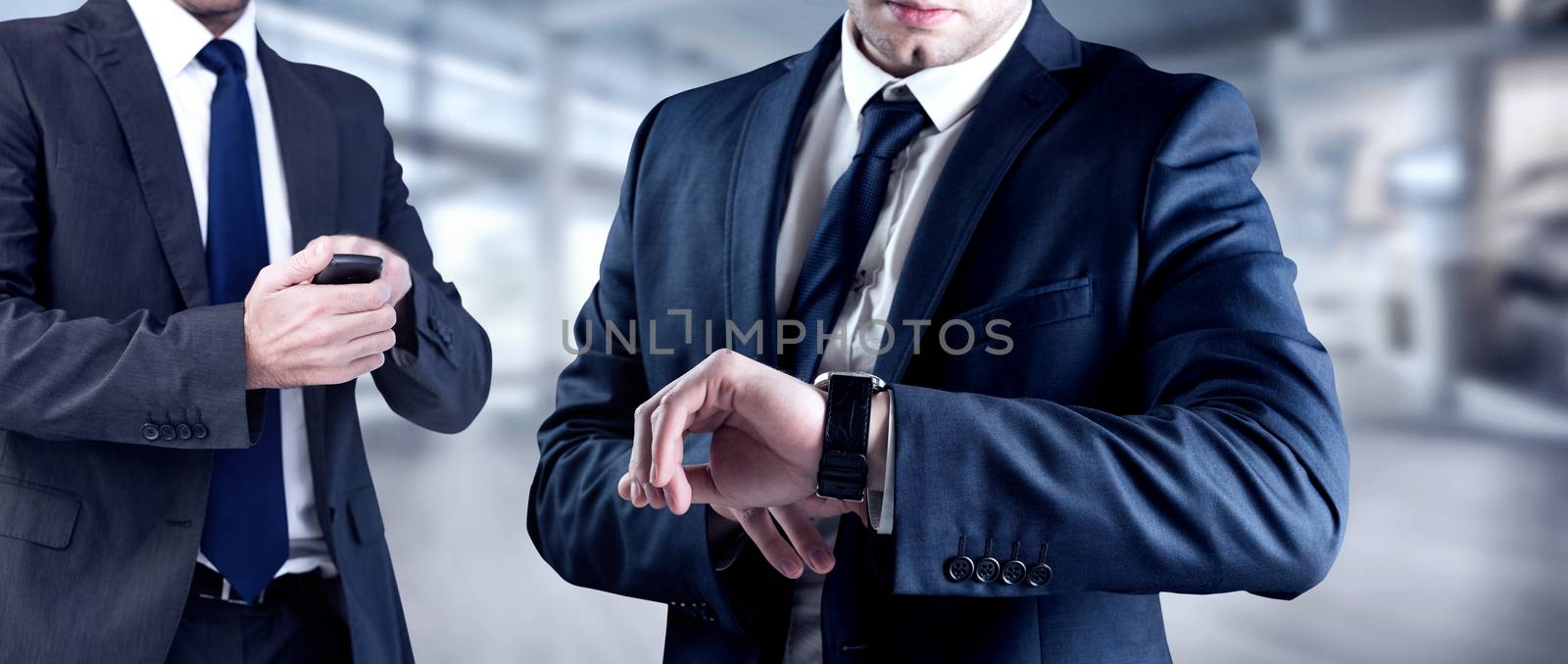 Composite image of focused businessman texting on his mobile phone by Wavebreakmedia