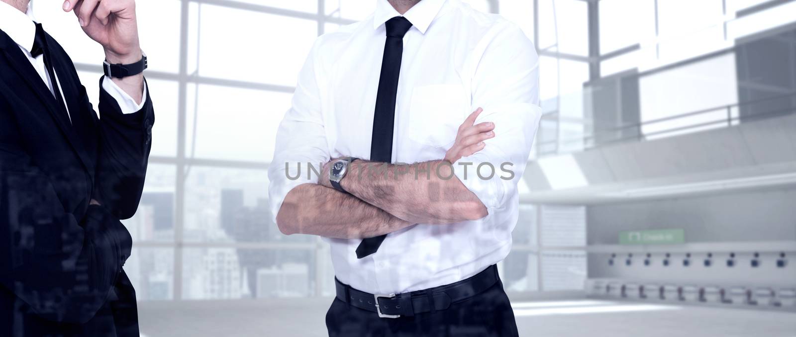 Smiling businessman with arms crossed against airport terminal 