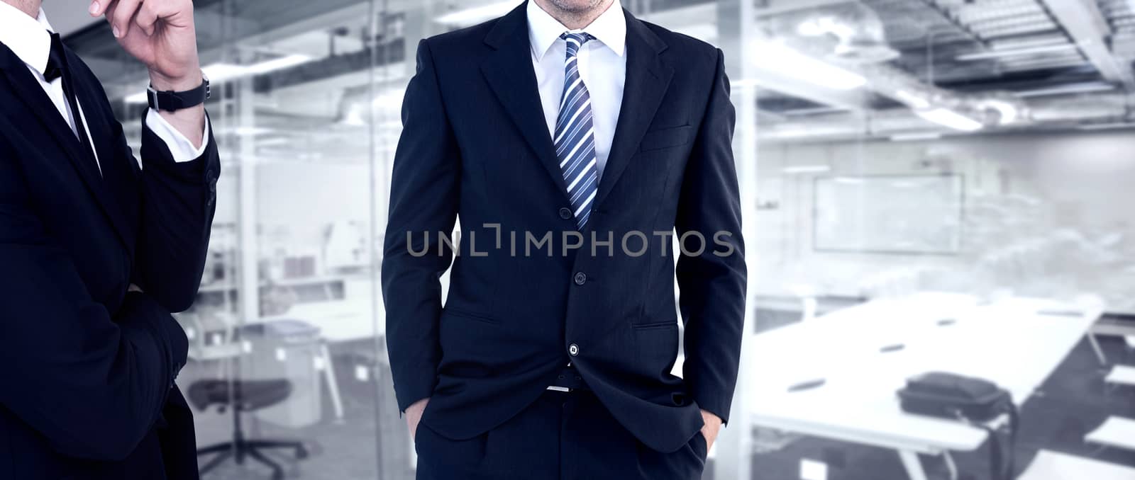 Smiling businessman standing with hands in pockets against classroom