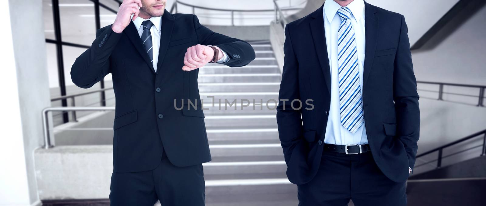 Smiling elegant businessman with hands in pockets against empty stair way 