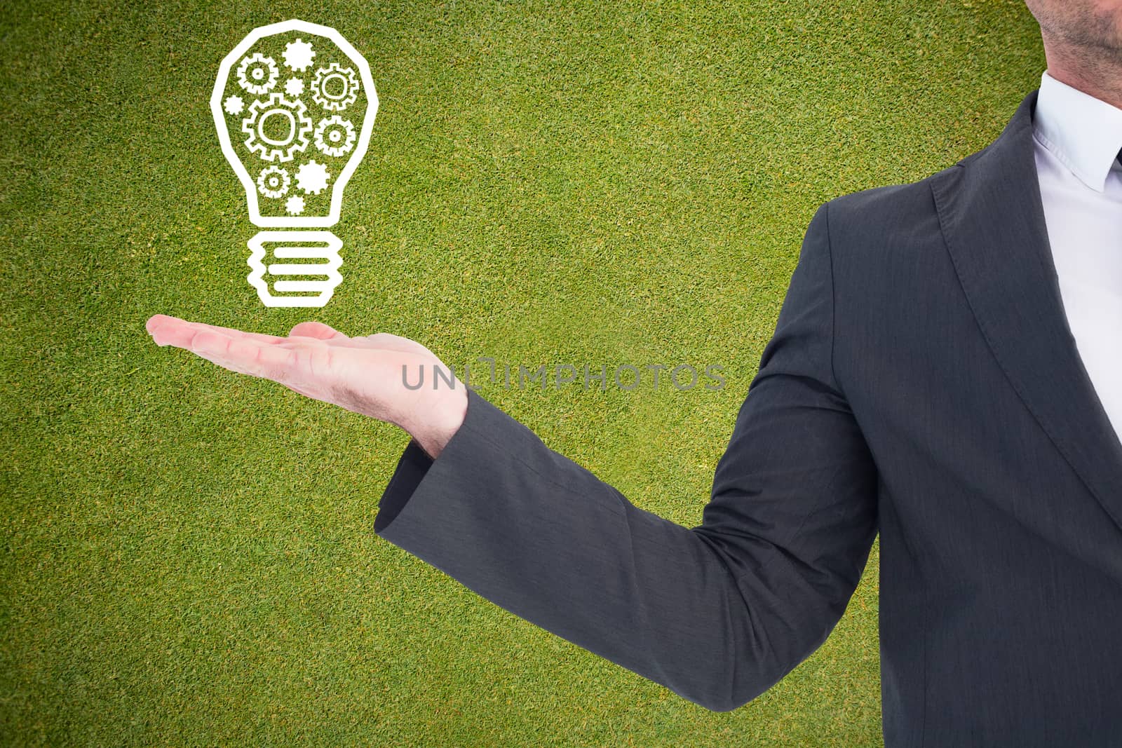 Businessman with his hand out against green background