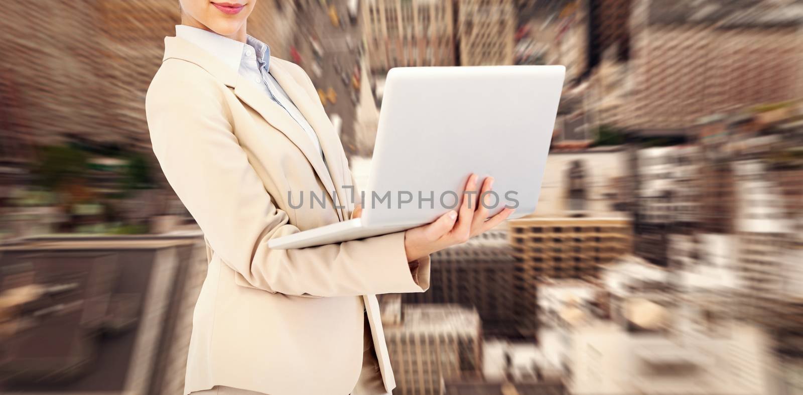Confident young businesswoman with laptop against new york