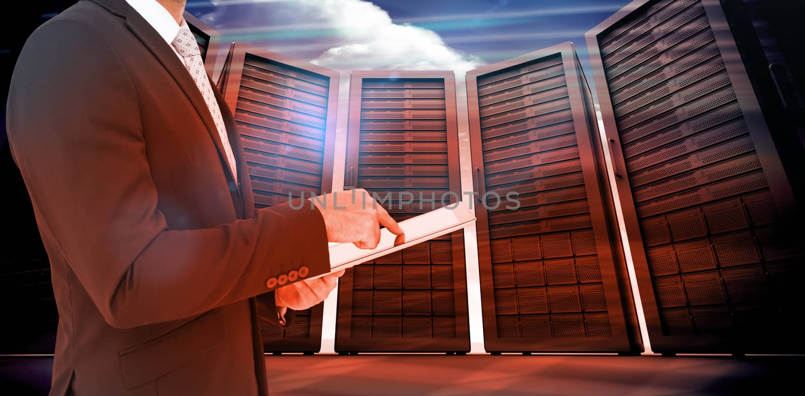 Businessman using his tablet pc  against composite image of server room