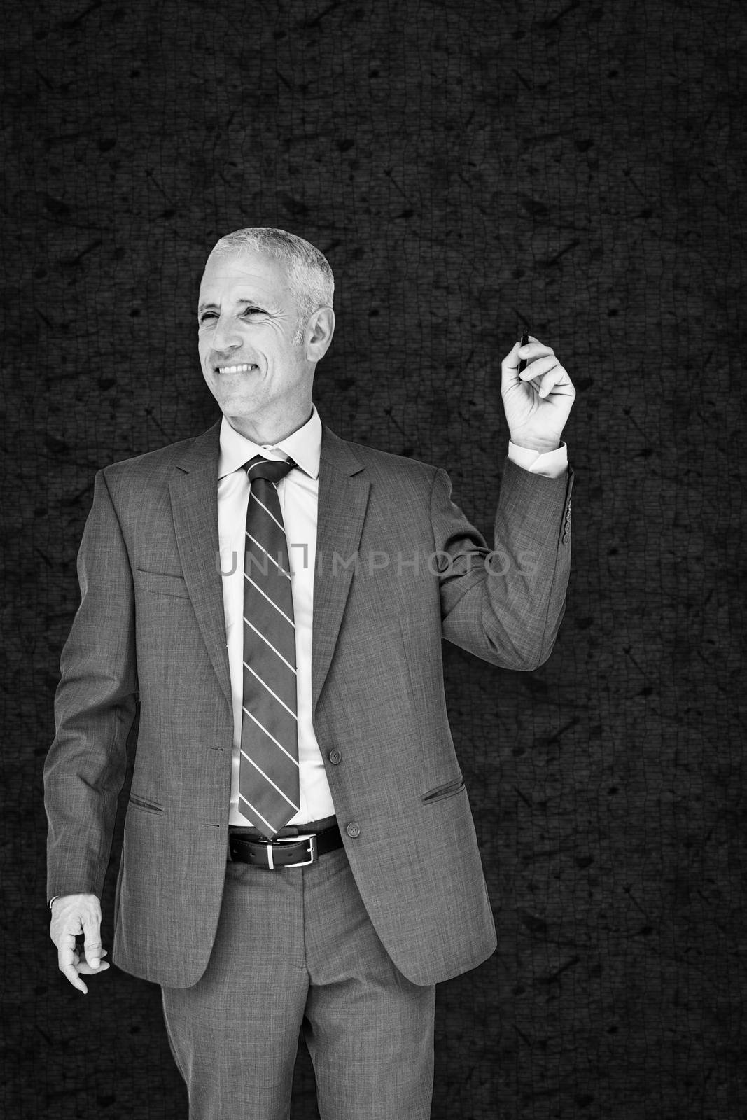 Businessman holding marker against grey background