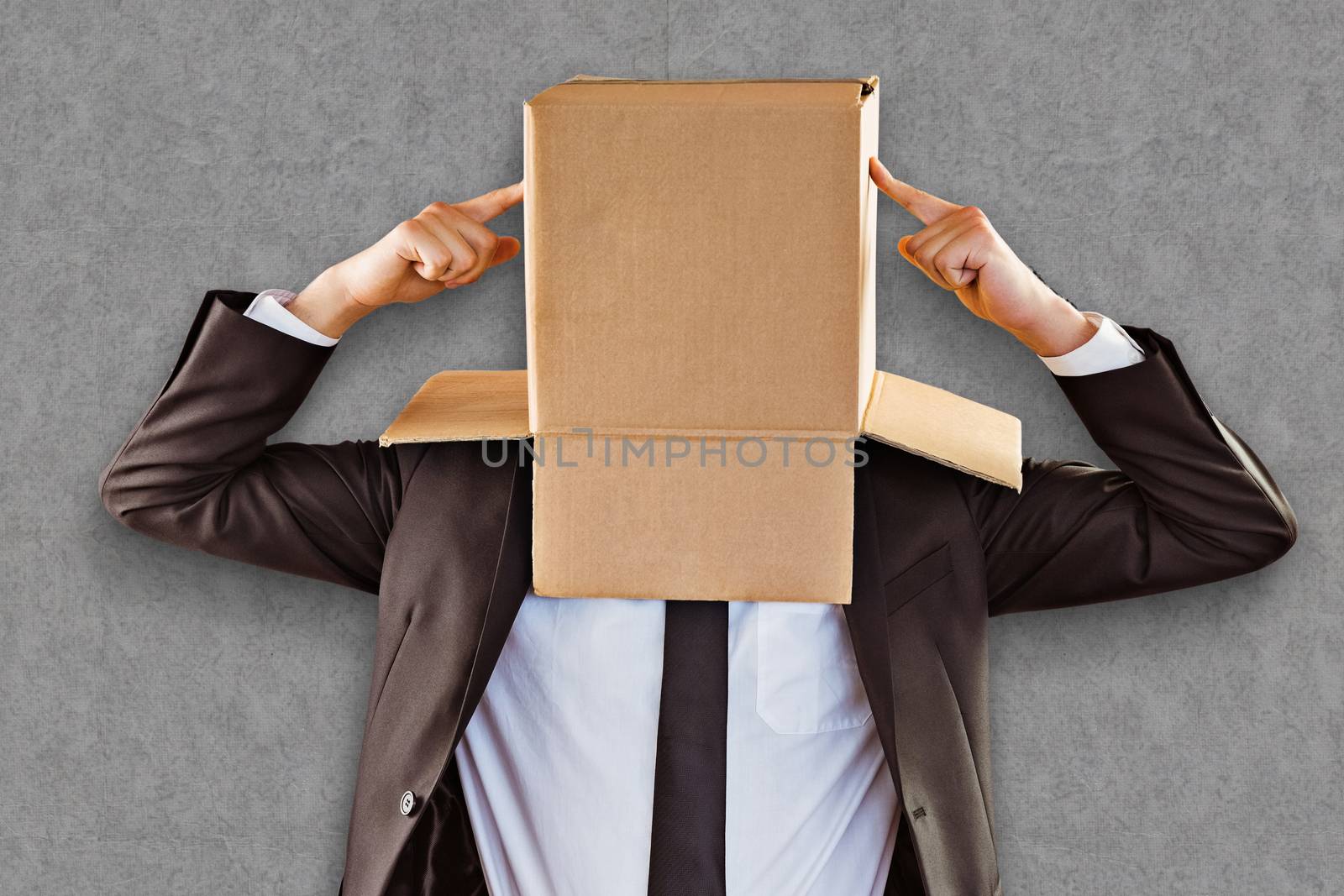 Anonymous businessman pointing to box against grey background