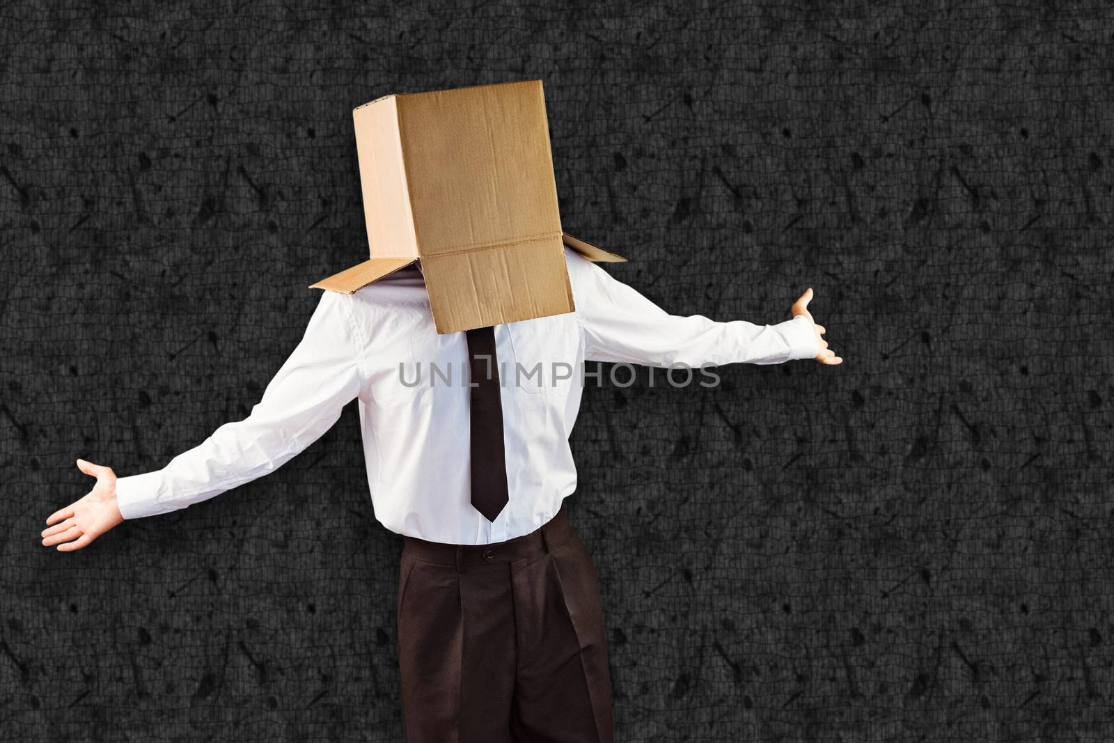 Anonymous businessman with arms out against grey background