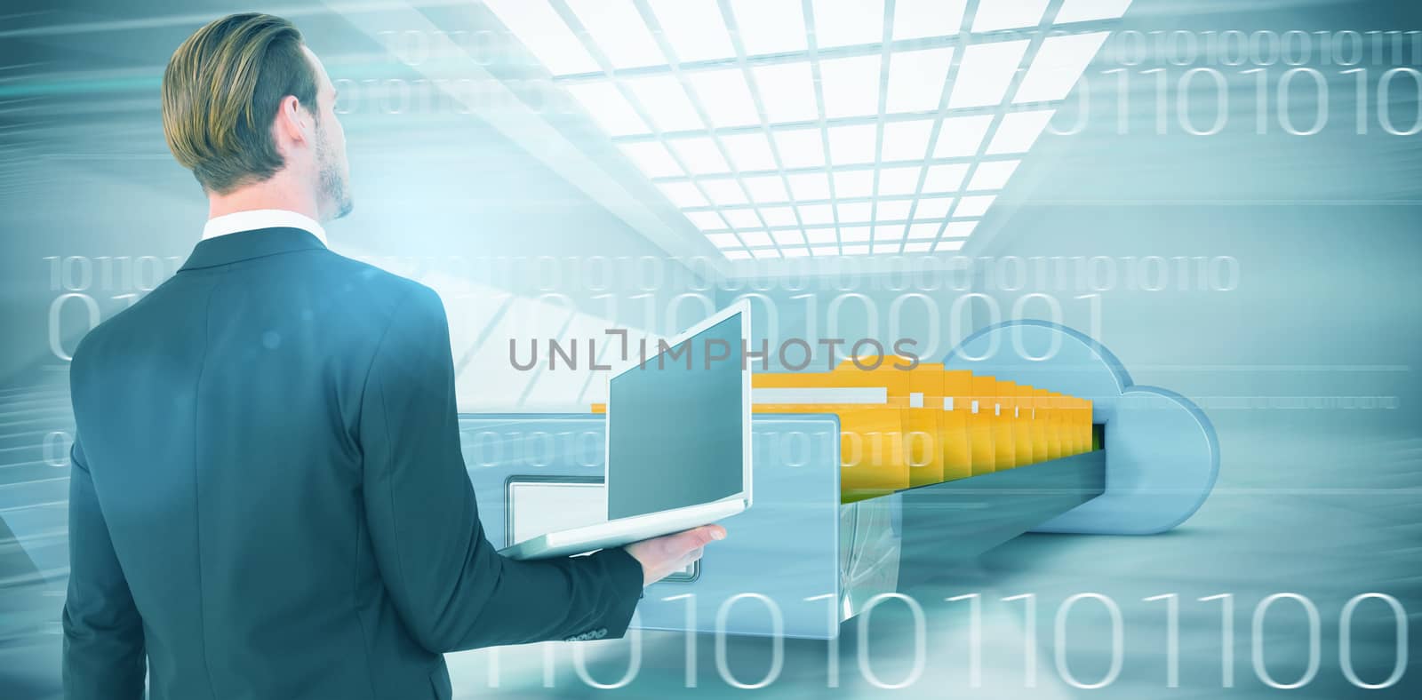 Businessman looking up holding laptop against composite image of cloud computing drawer