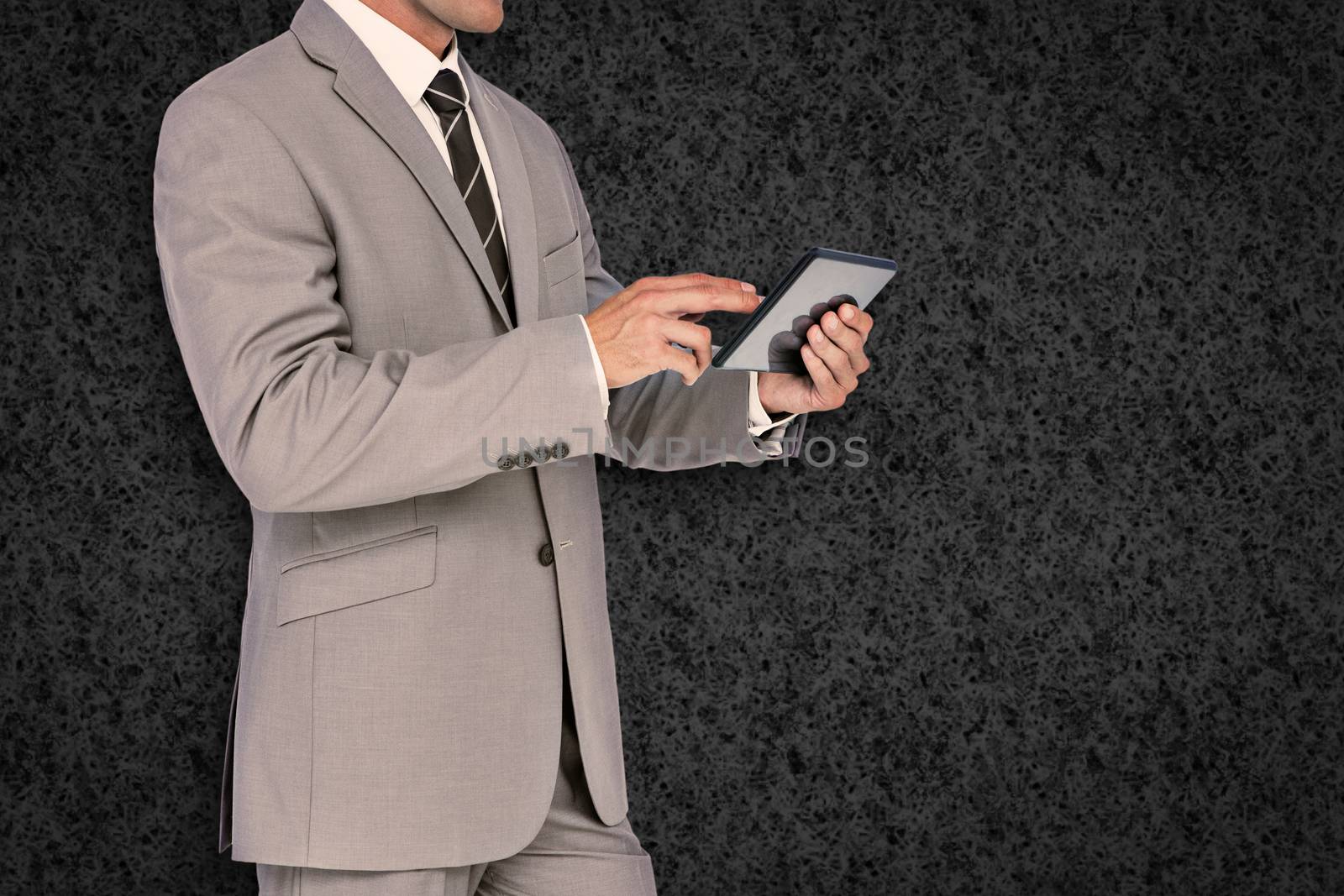 Businessman using tablet pc against grey background