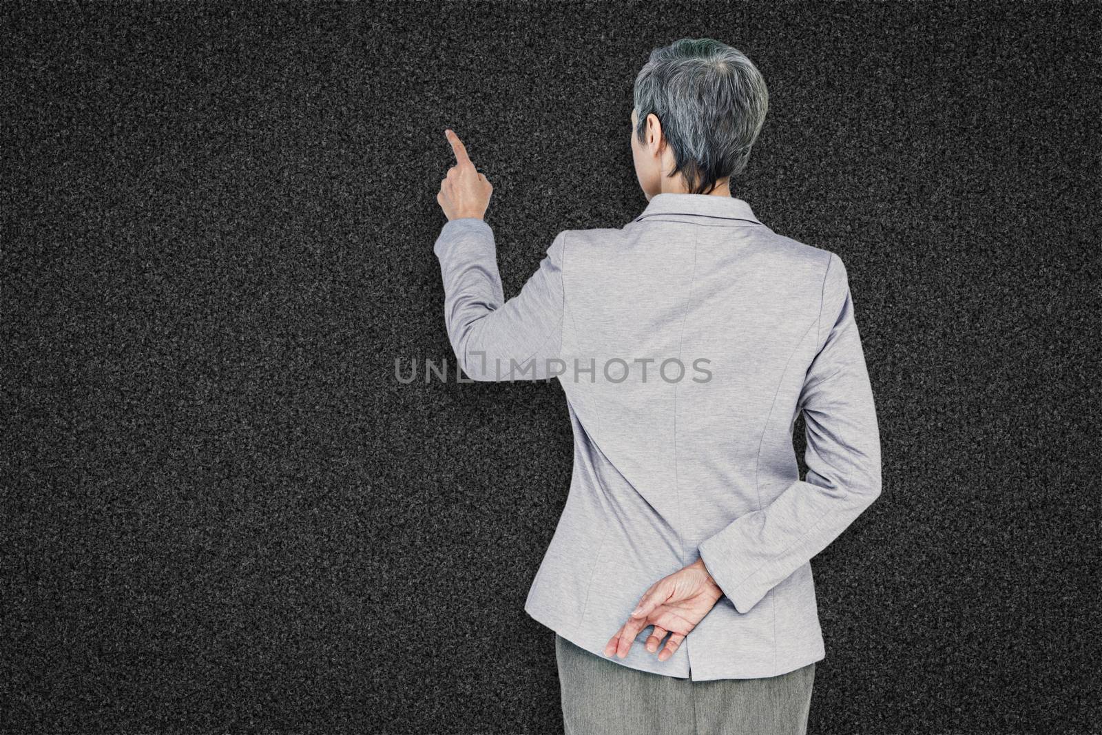 Businesswoman pointing against black background
