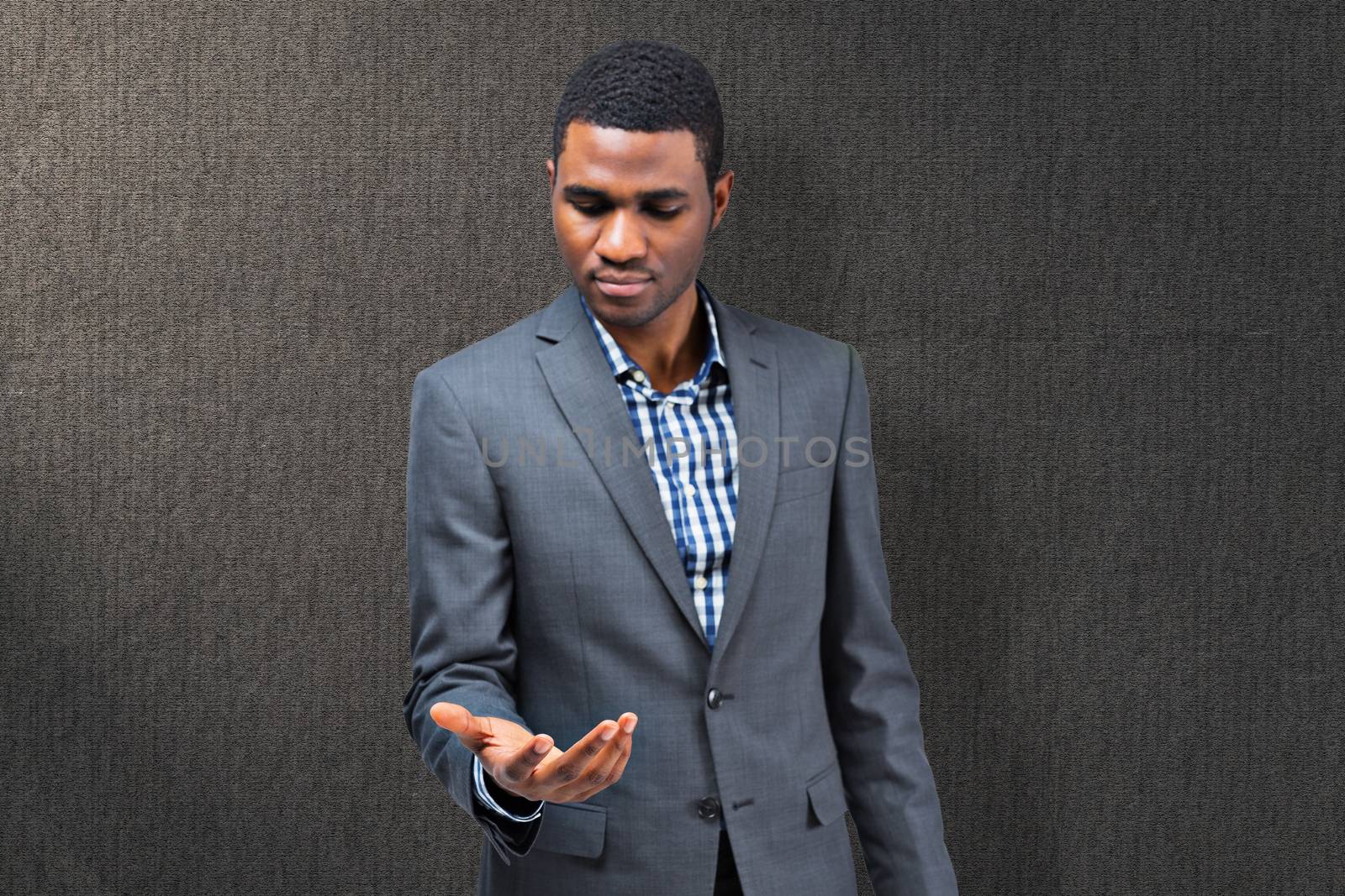 Focused businessman holding hand out against grey background