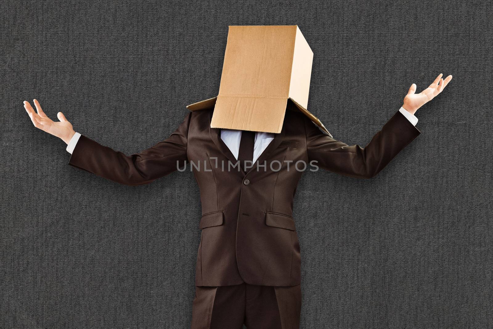 Anonymous businessman holding his hands out against grey background