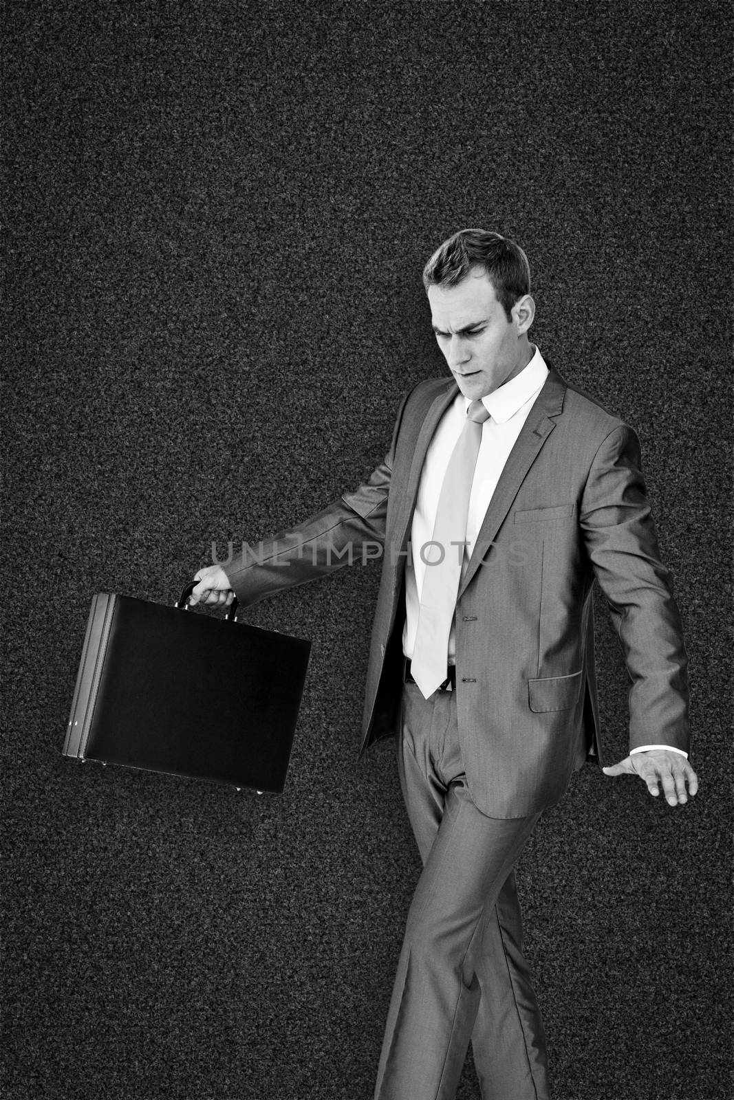 Businessman walking with his briefcase against black background