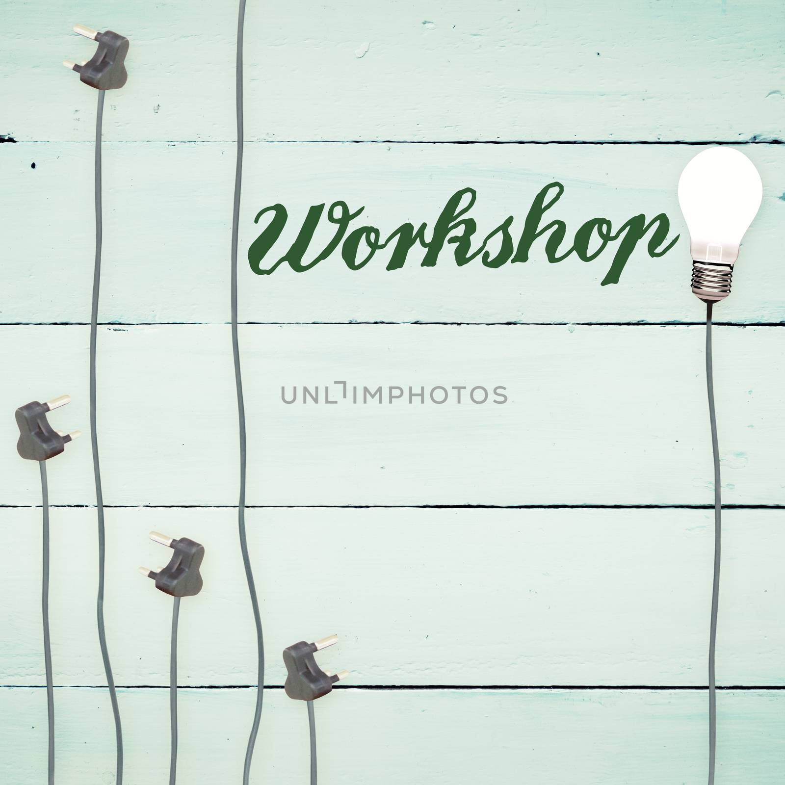 The word workshop against light bulbs on wooden background