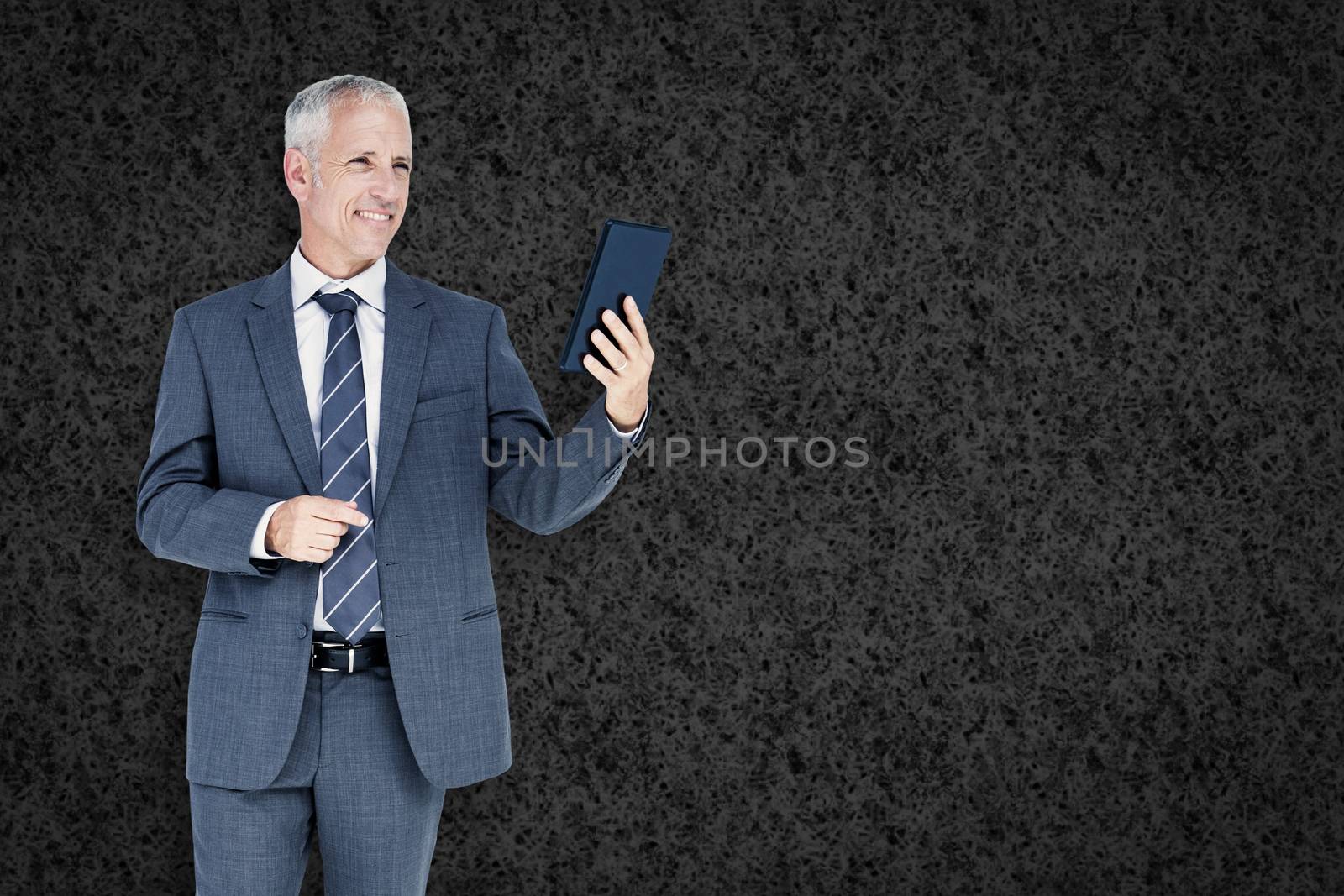 Businessman using tablet against grey background