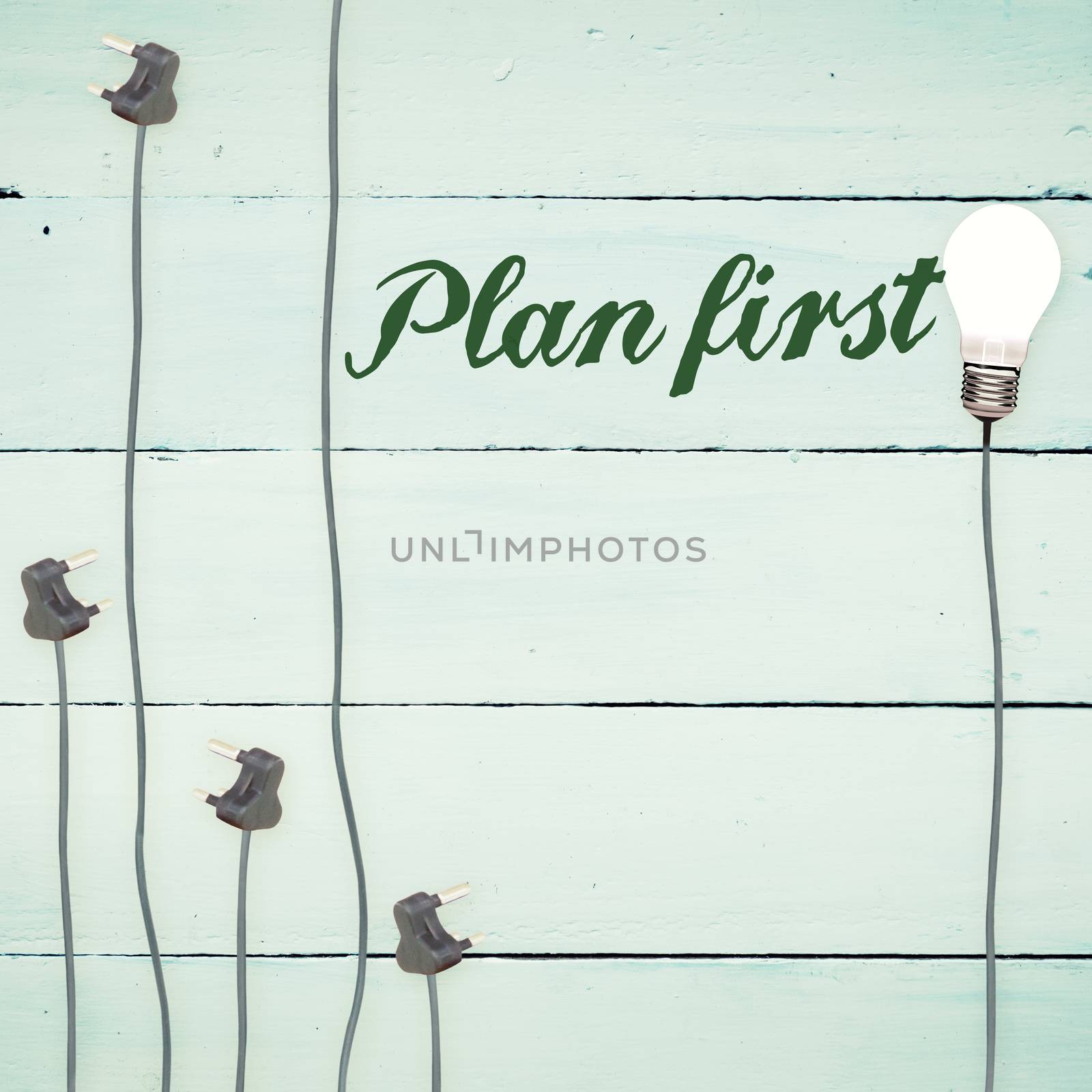 The word plan first against light bulbs on wooden background