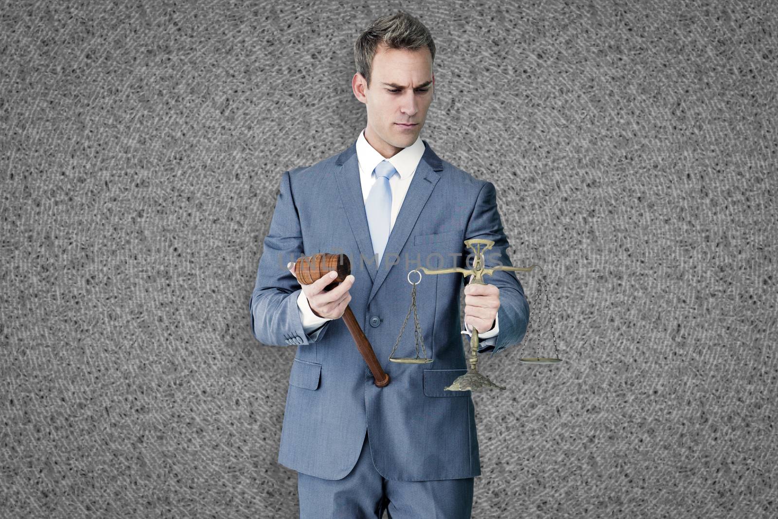 Businessman holding scales of justice against grey background