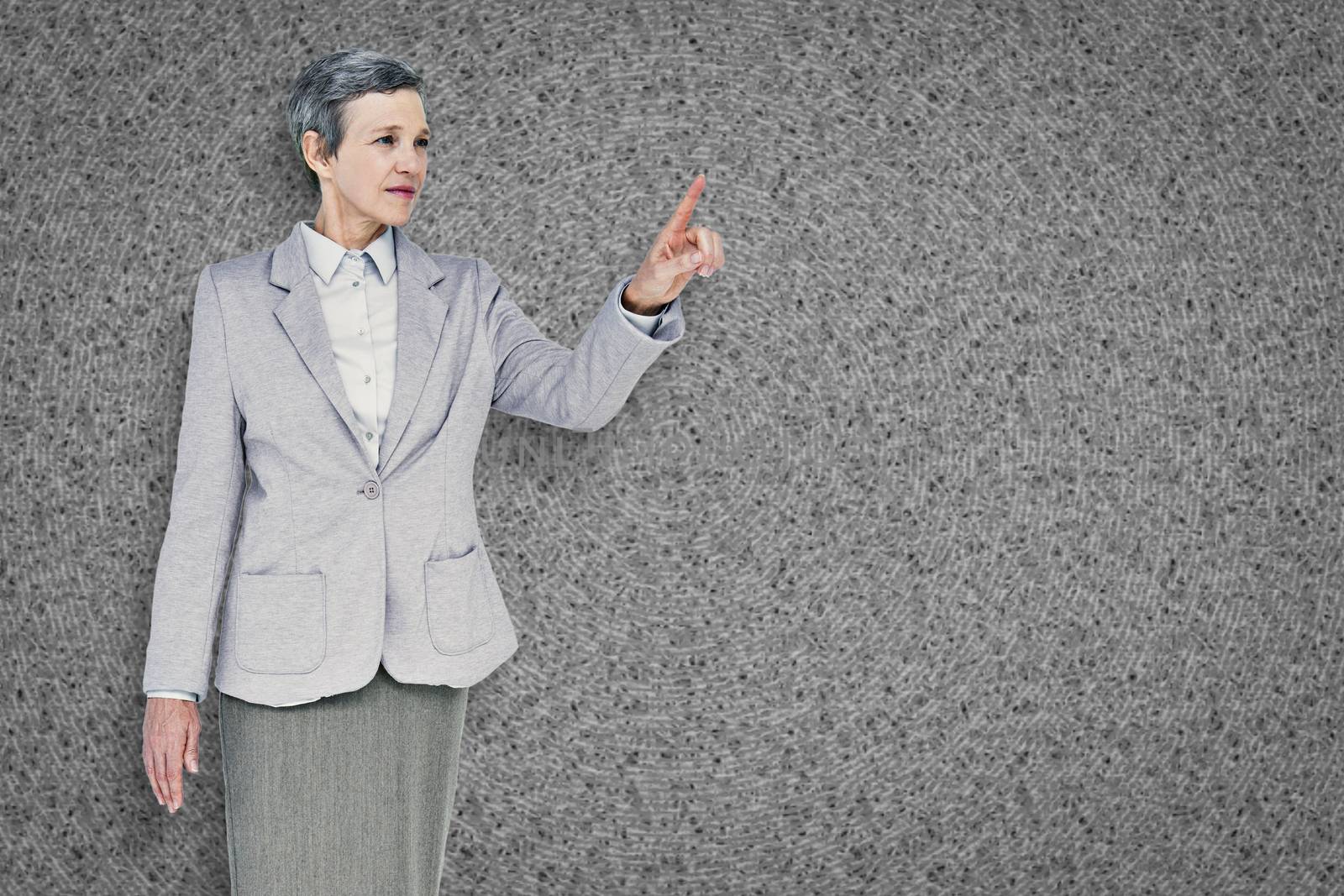 Businesswoman pointing against grey background