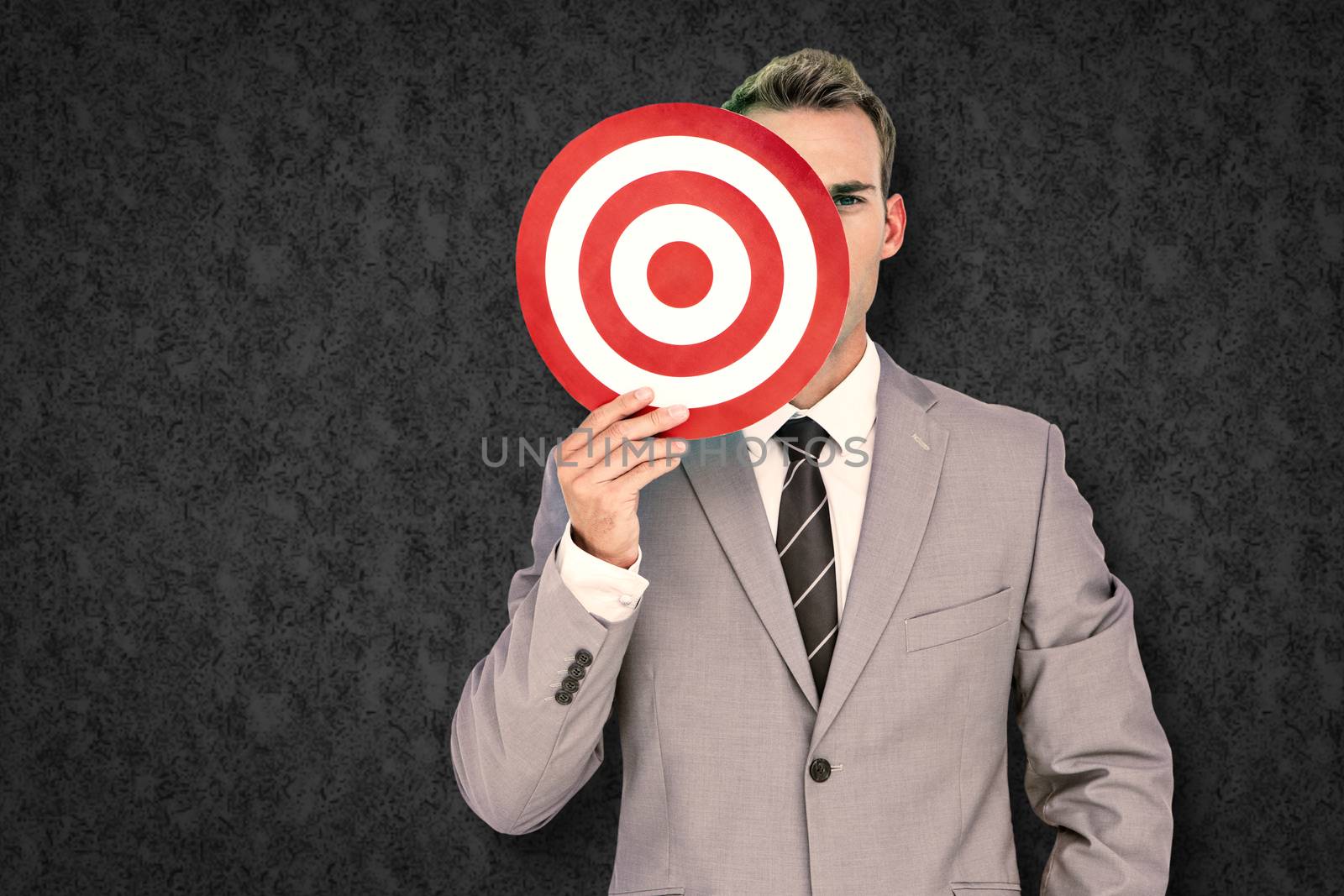 Composite image of businessman holding target by Wavebreakmedia