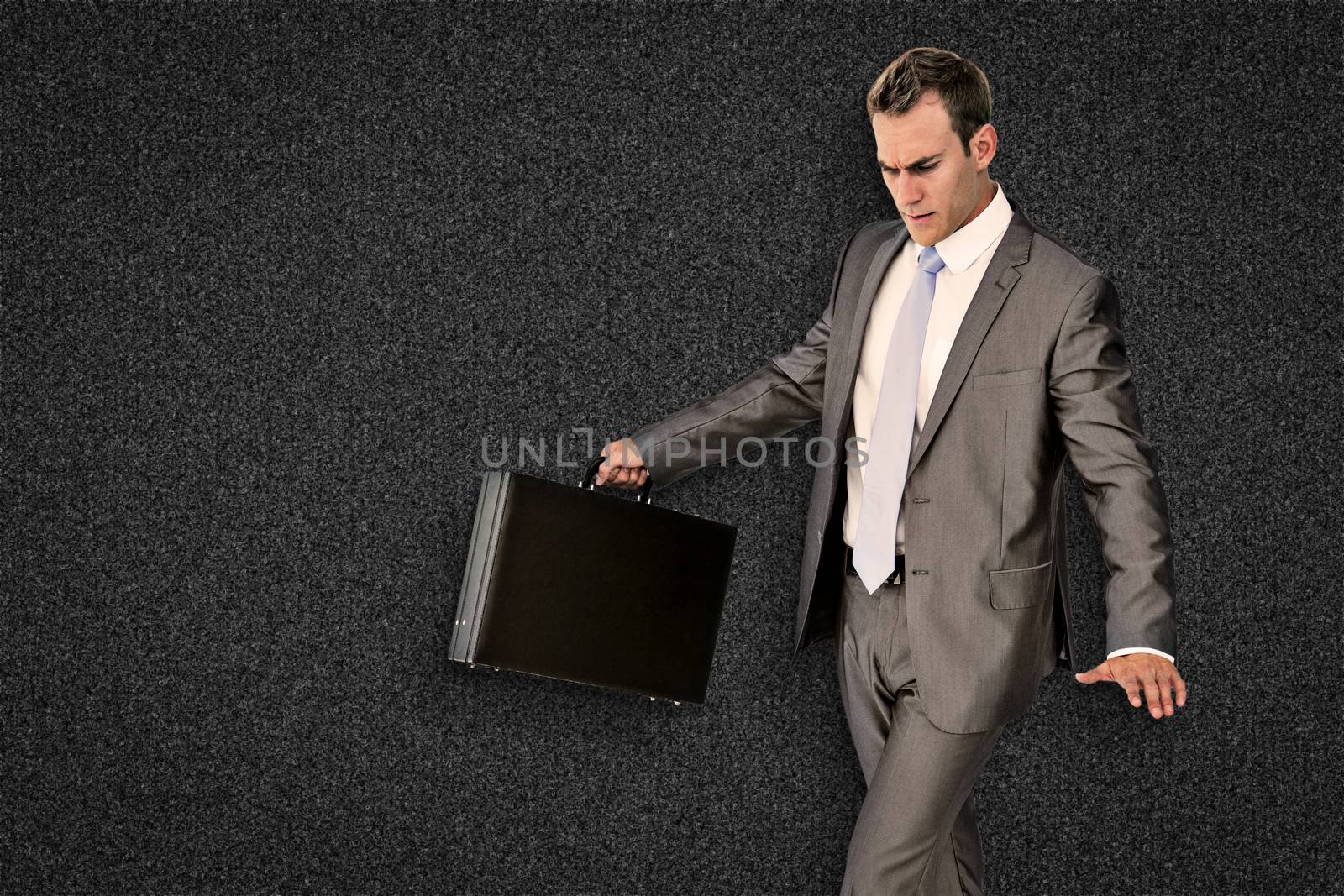 Businessman walking with his briefcase against black background