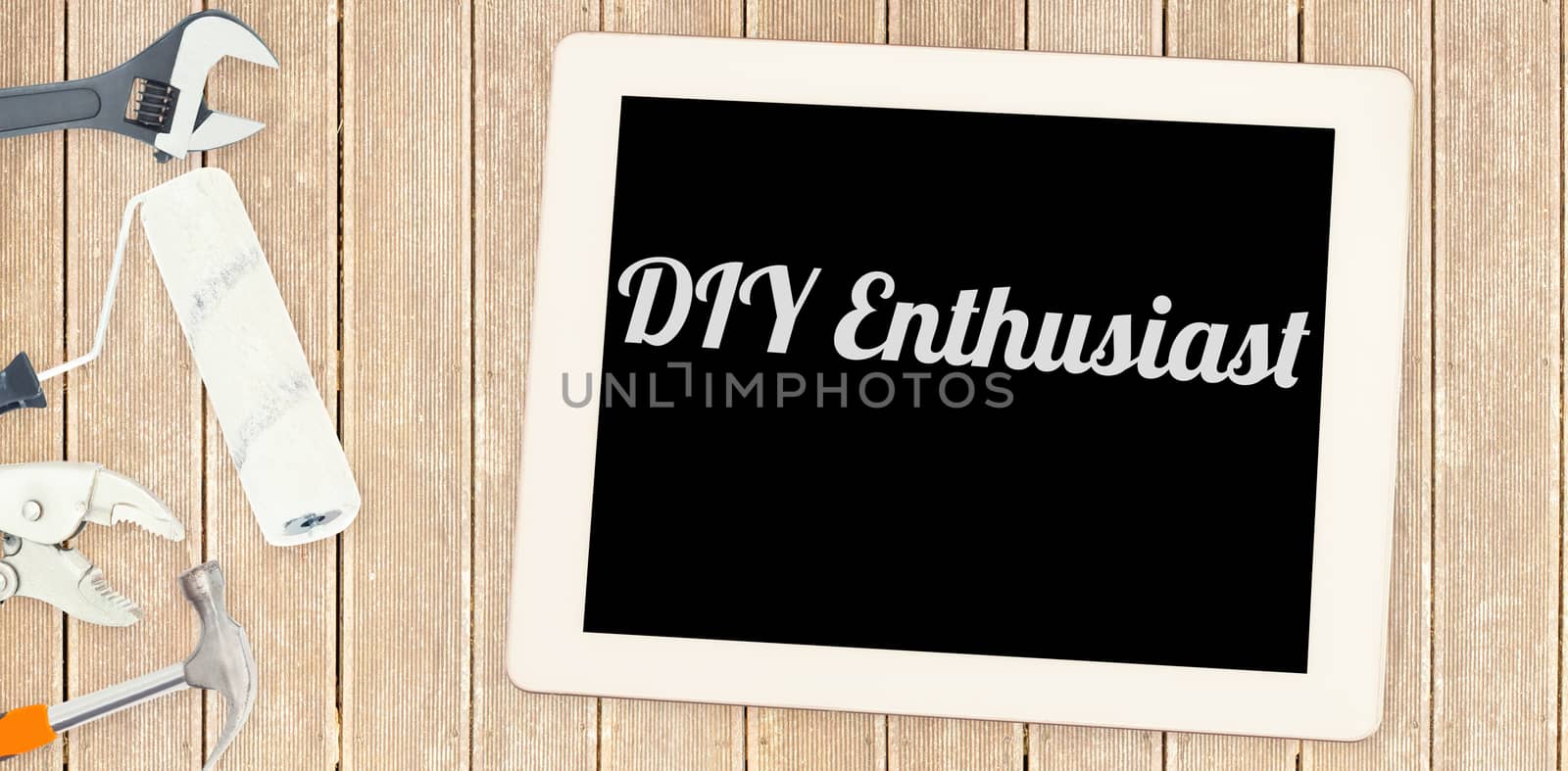 The word diy enthusiast against tools and tablet on wooden background