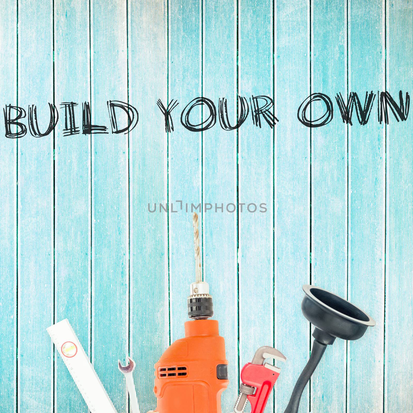 The word build your own against tools on wooden background