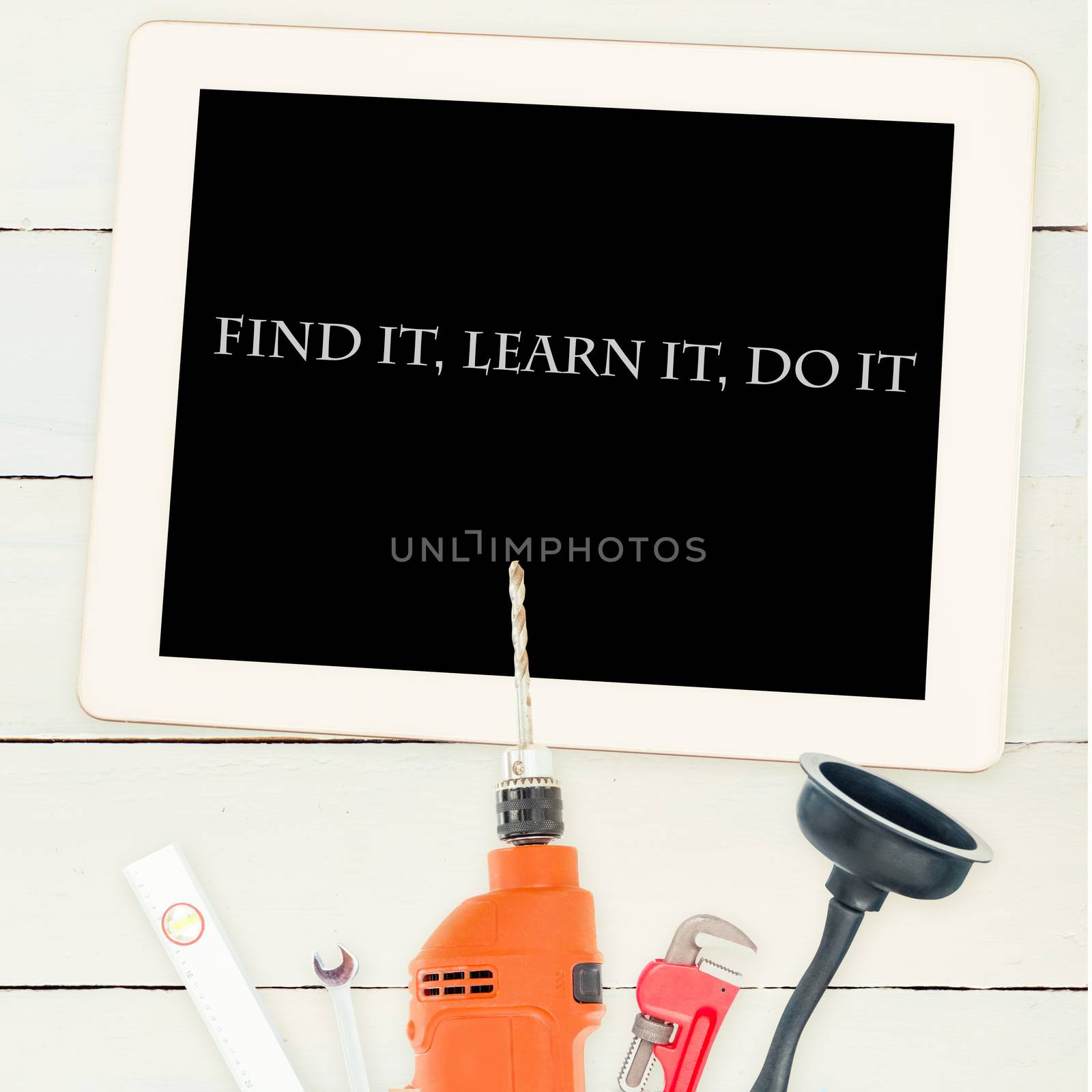 Find it, learn it, do it against tools and tablet on wooden background by Wavebreakmedia