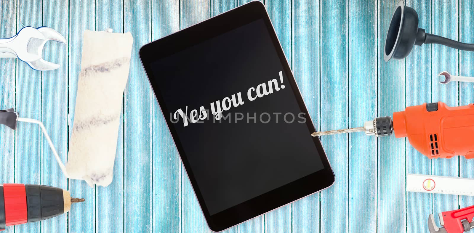 The word yes you can! against tools and tablet on wooden background