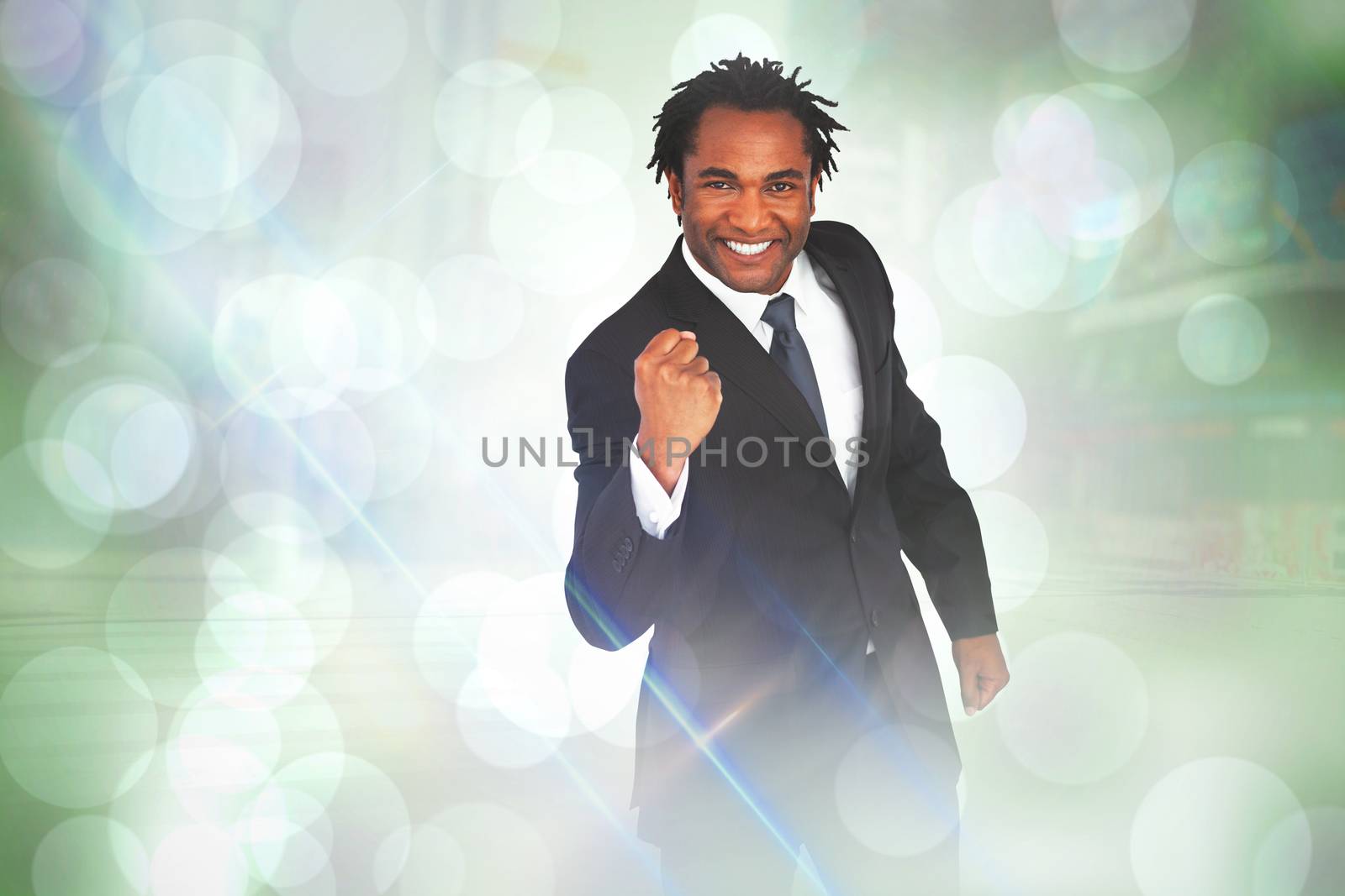 Composite image of happy businessman with fist by Wavebreakmedia