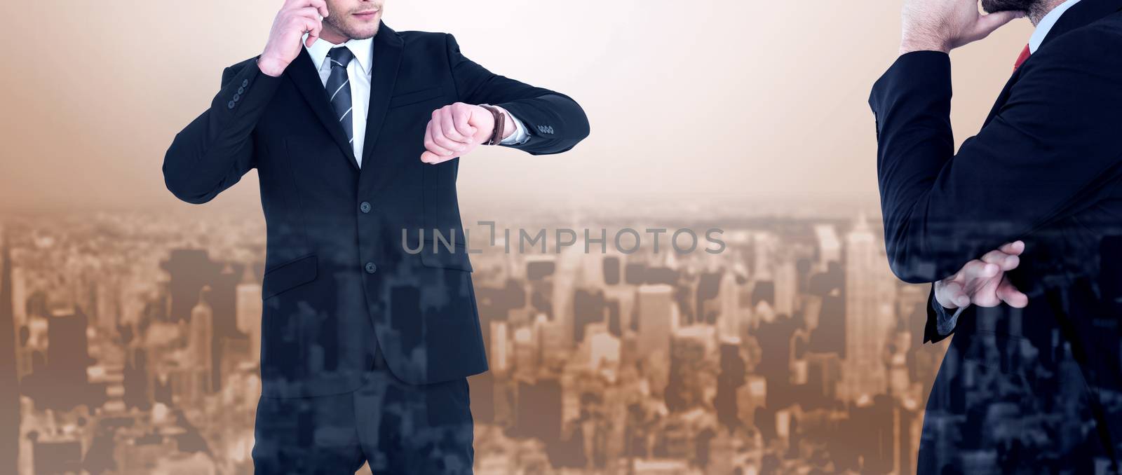 Serious businessman phoning while checking time against high angle view of city