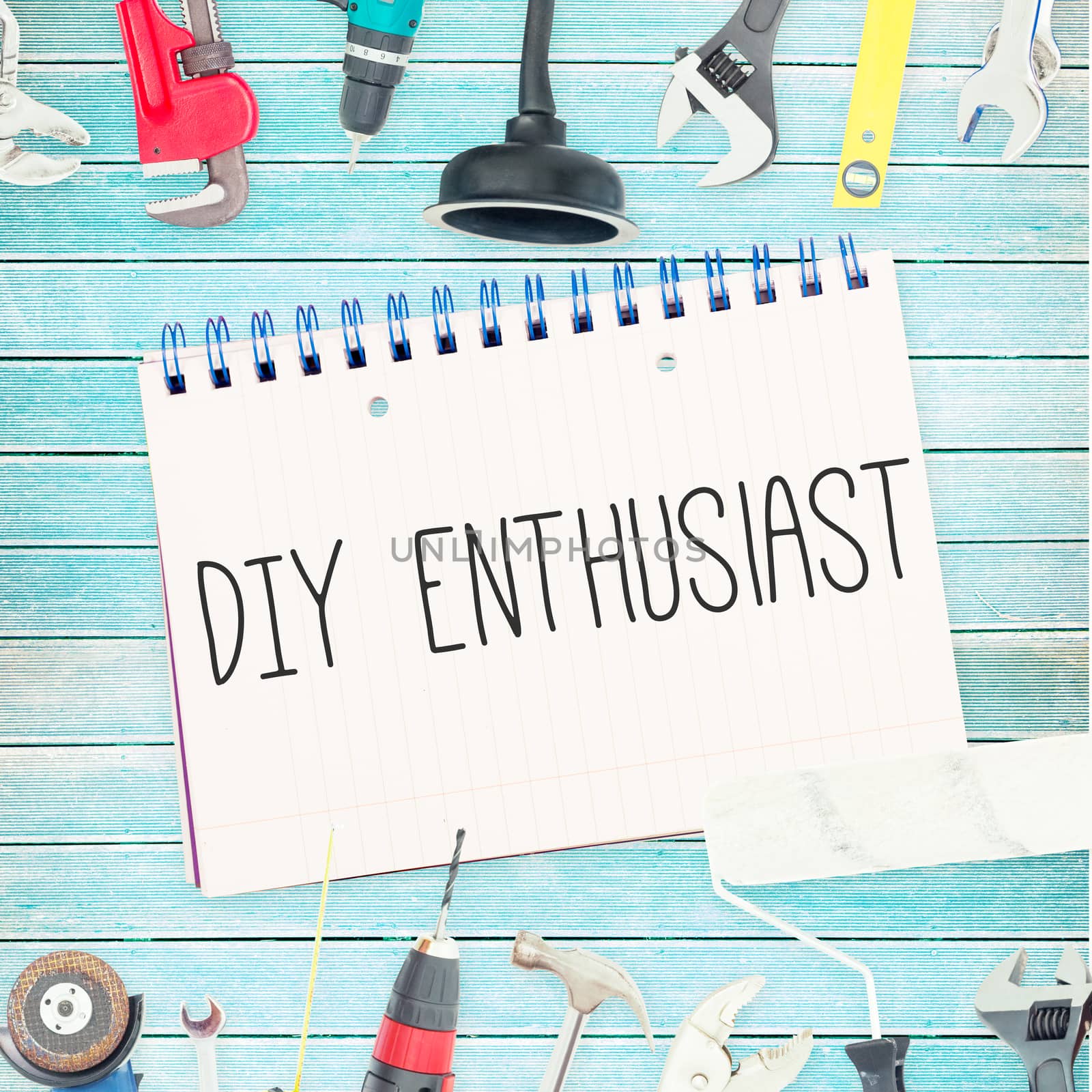 The word diy enthusiast against tools and notepad on wooden background